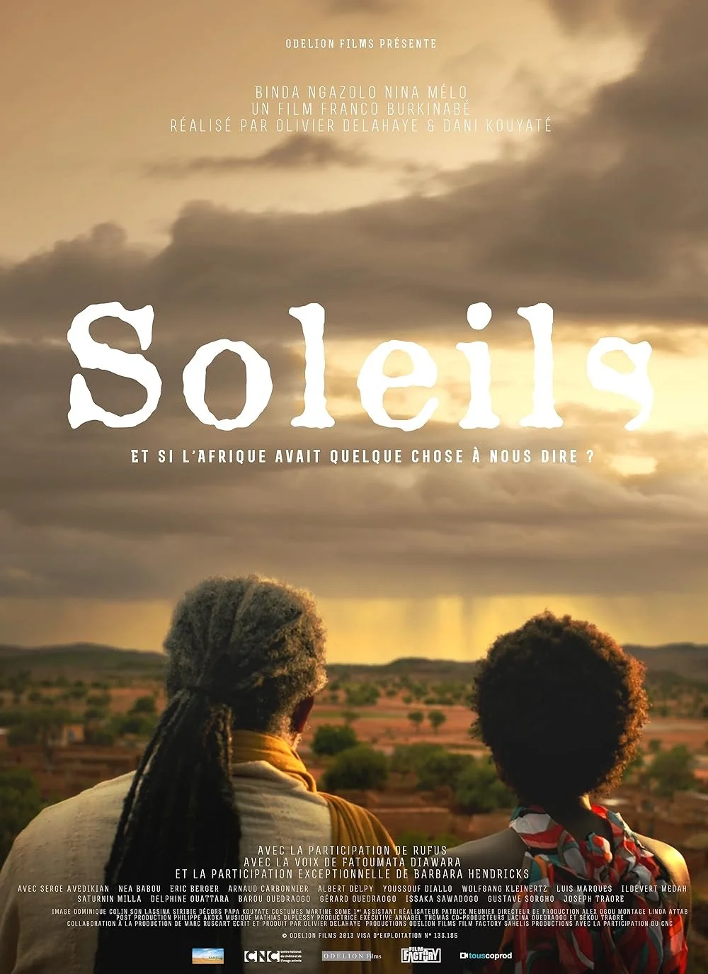 A movie poster titled "Soleil" with a dark cloudy sky in the background, featuring two people with Afro hairstyles looking over a rural landscape at sunset.
