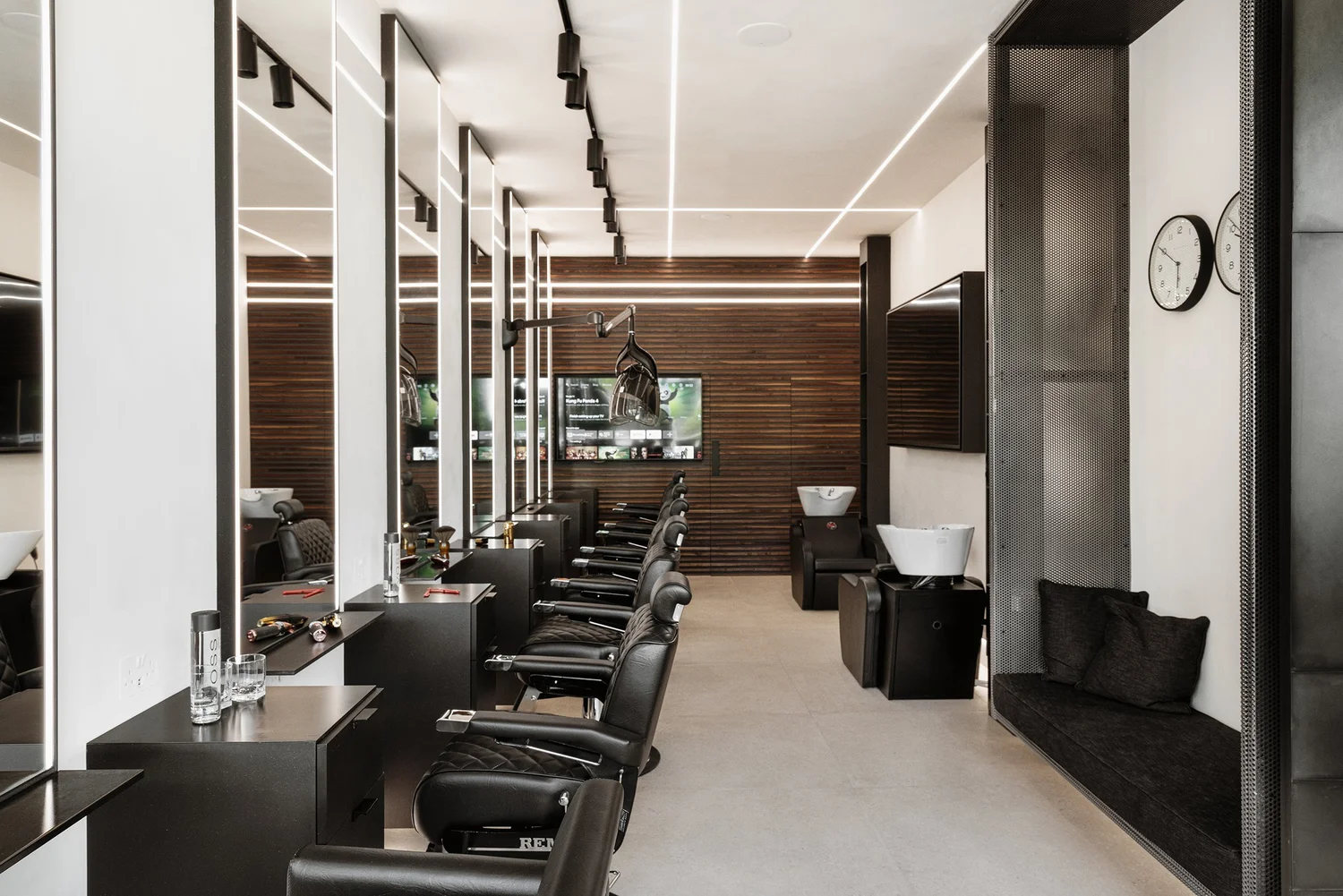 Row of barber chairs and backlit mirrors