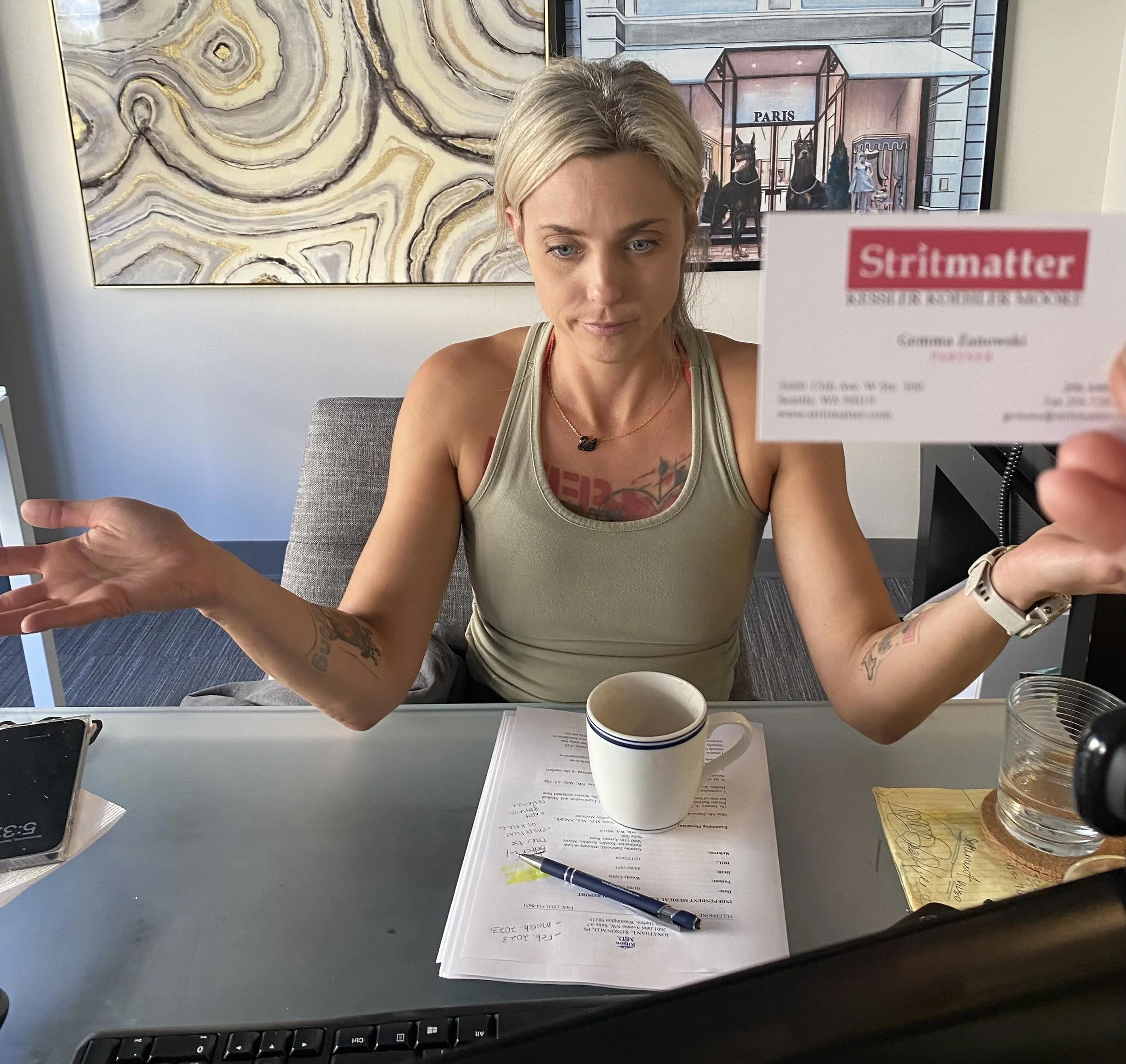 Gemma sitting at her desk holding up her Stritmatter business card