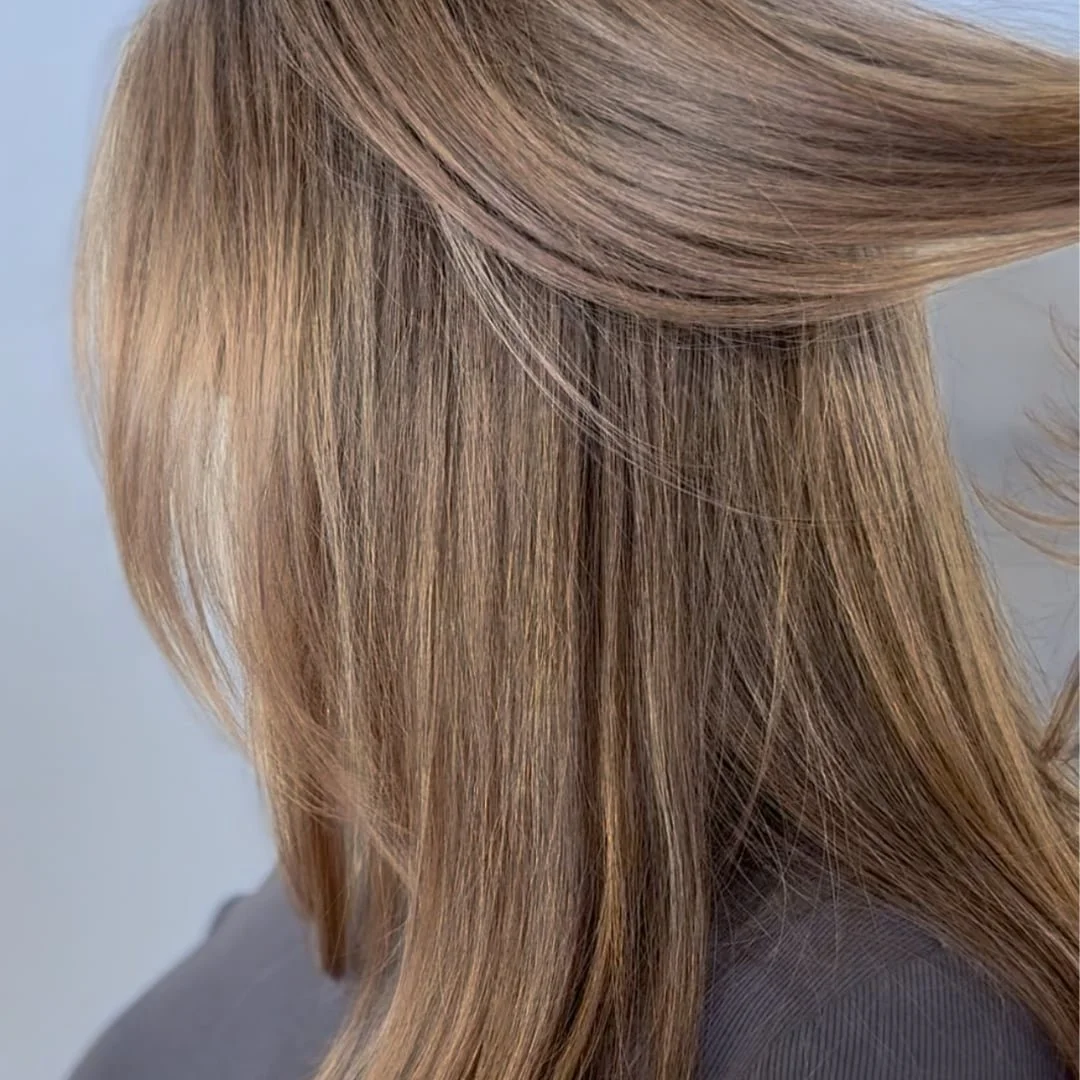 This is an image of a woman who used gray-blending to blend her gray hair to a golden blonde with highlights and lowlights for low-maintenance color options