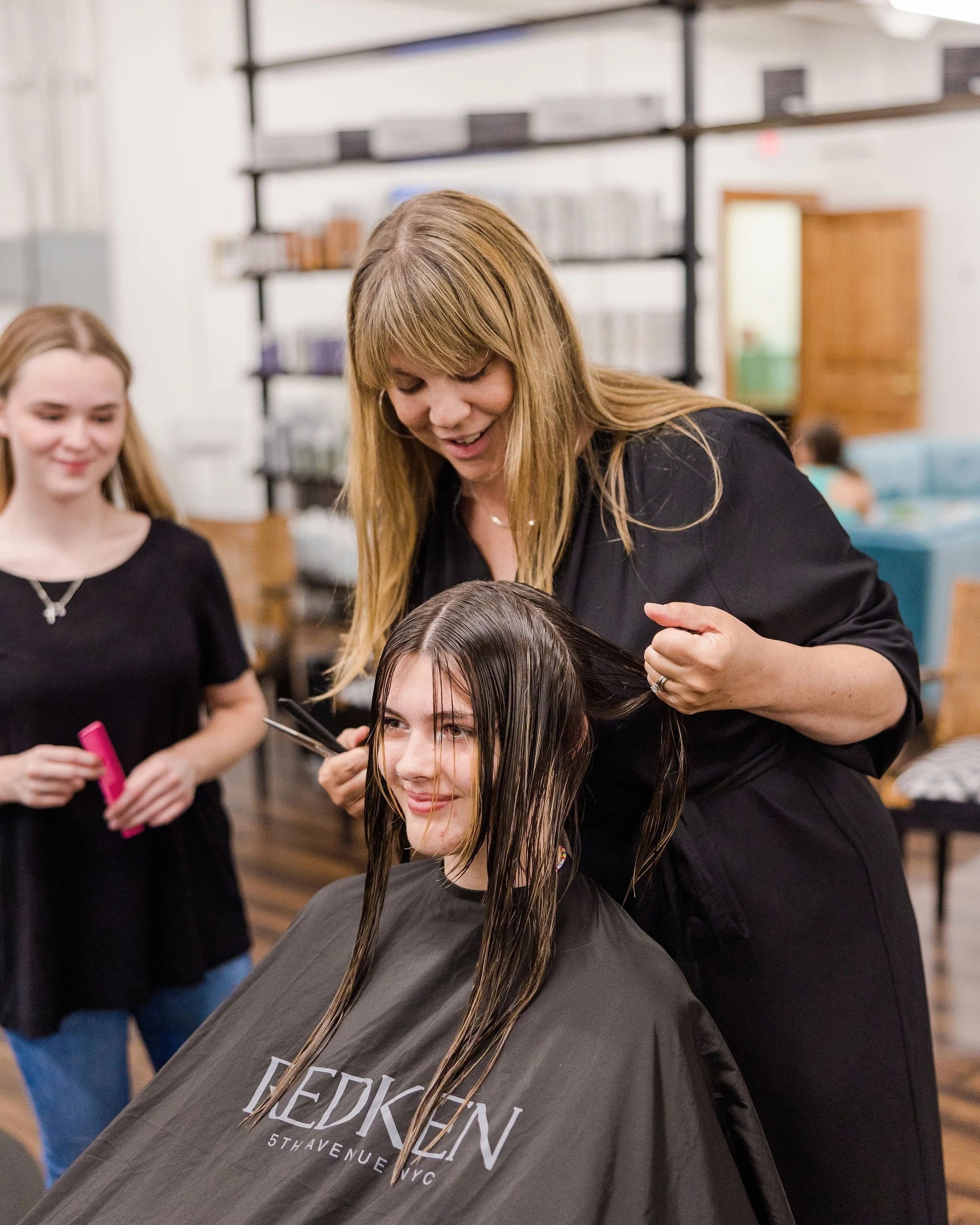 b.LUXE owner Heather Cohen guiding an apprentice stylist during a haircut at the Medway, Massachusetts salon.