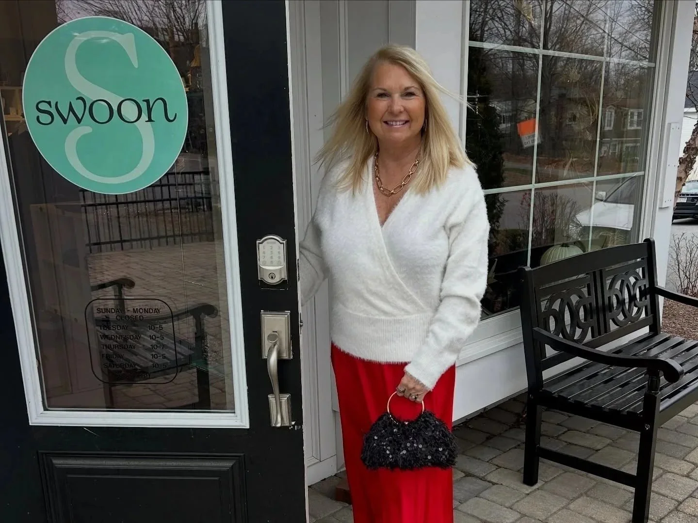 Beautiful blonde woman wearing winter white wrap sweater and bright holiday red pants
