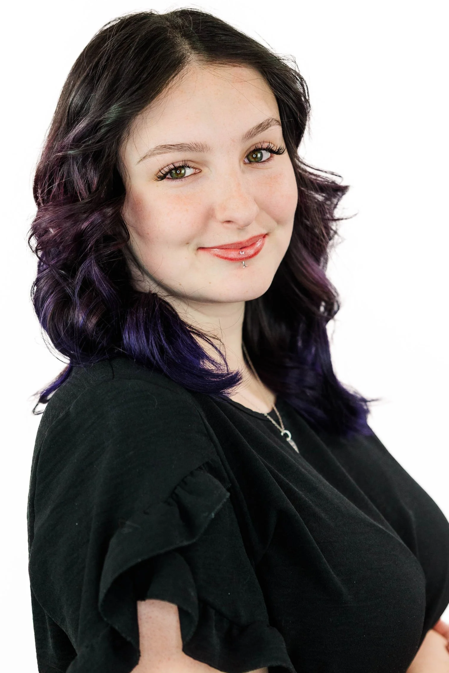Woman with blonde hair in floral dress, smiling.