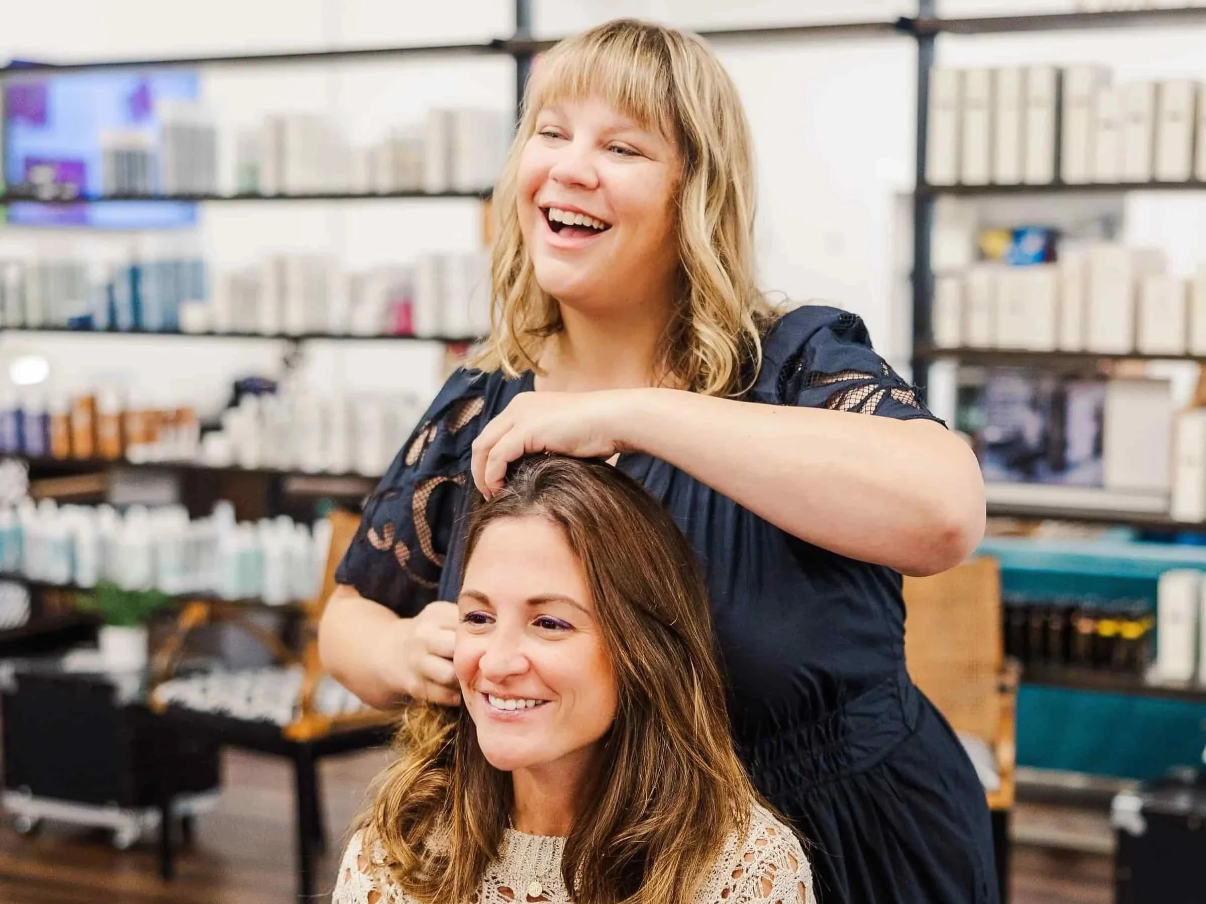 This is an image of Heather with a longtime customer during a consultation for a new hairstyle, laughing and enjoying the appointment