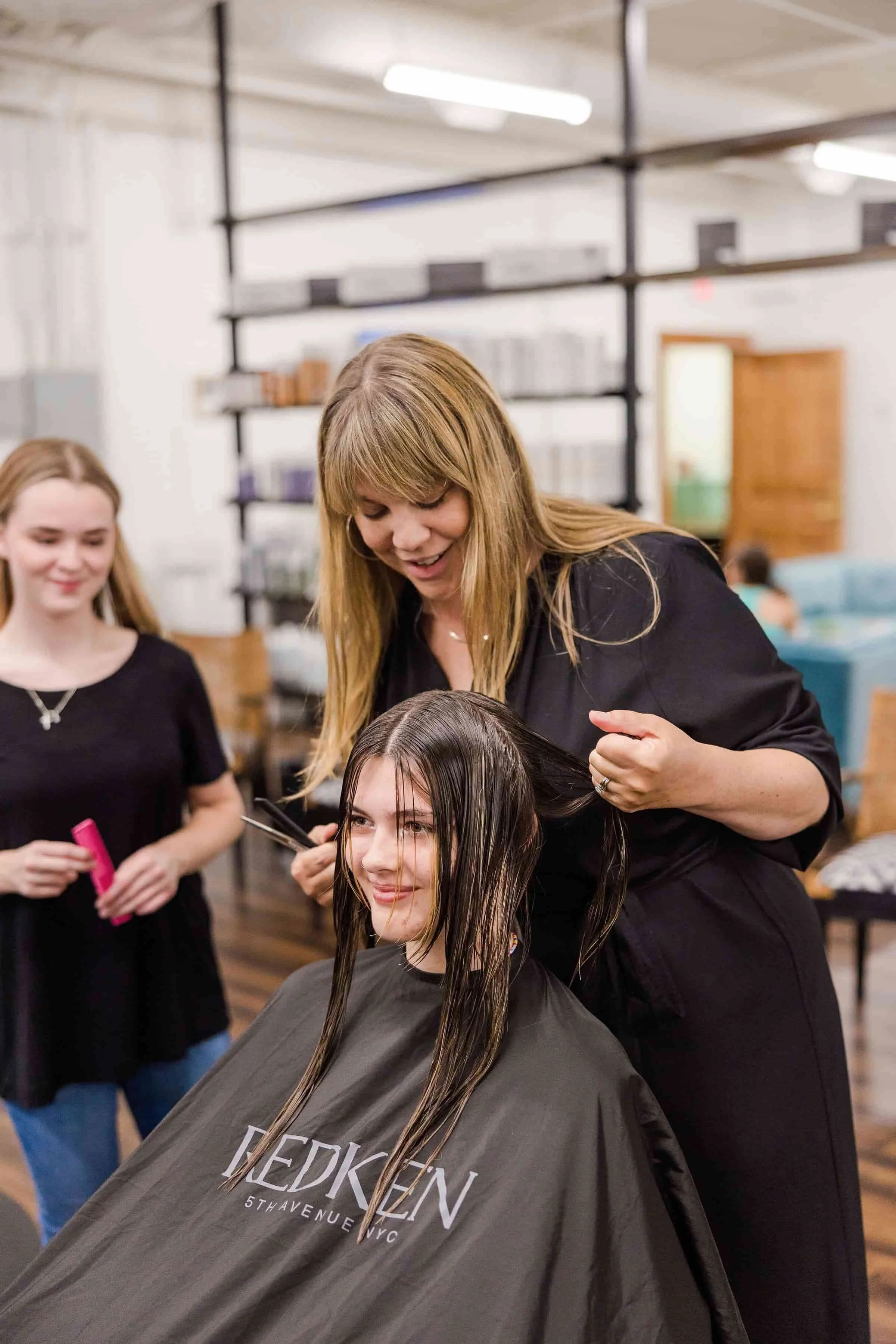 Here is an image of owner of bLUXE, Heather Cohen, teaching an apprentice new styling techniques because we're a teaching studio
