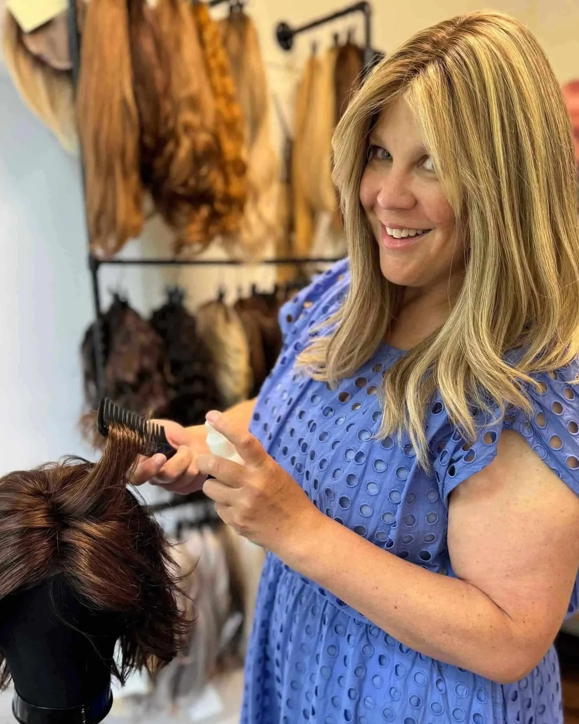 Here is a picture of Heather Cohen, owner of bLUXE wearing blonde wig and cornflower blue dress in wig room