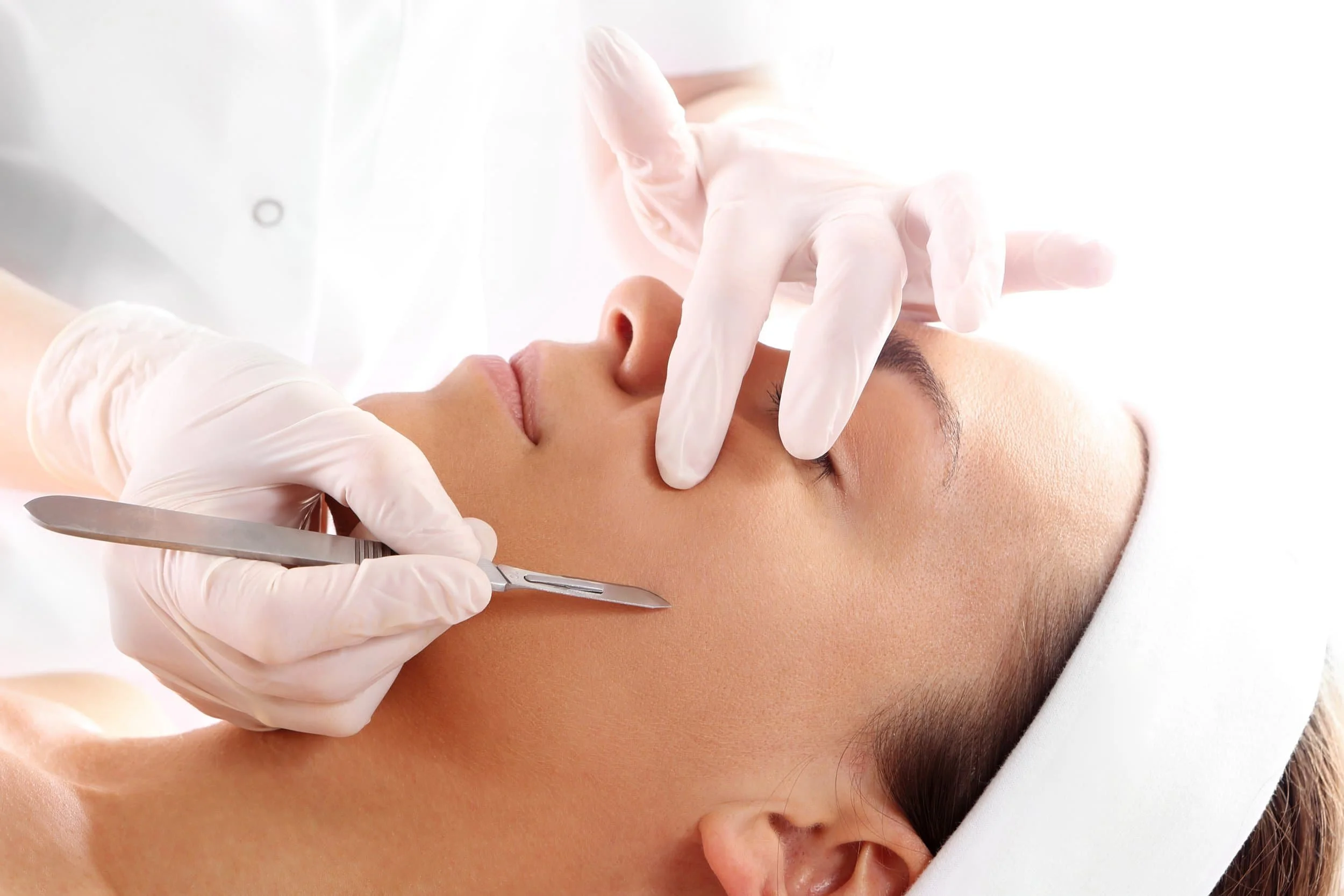 This is an image of a client getting a dermaplaning for the Power of 3 facial where they remove peach fuzz from the skin