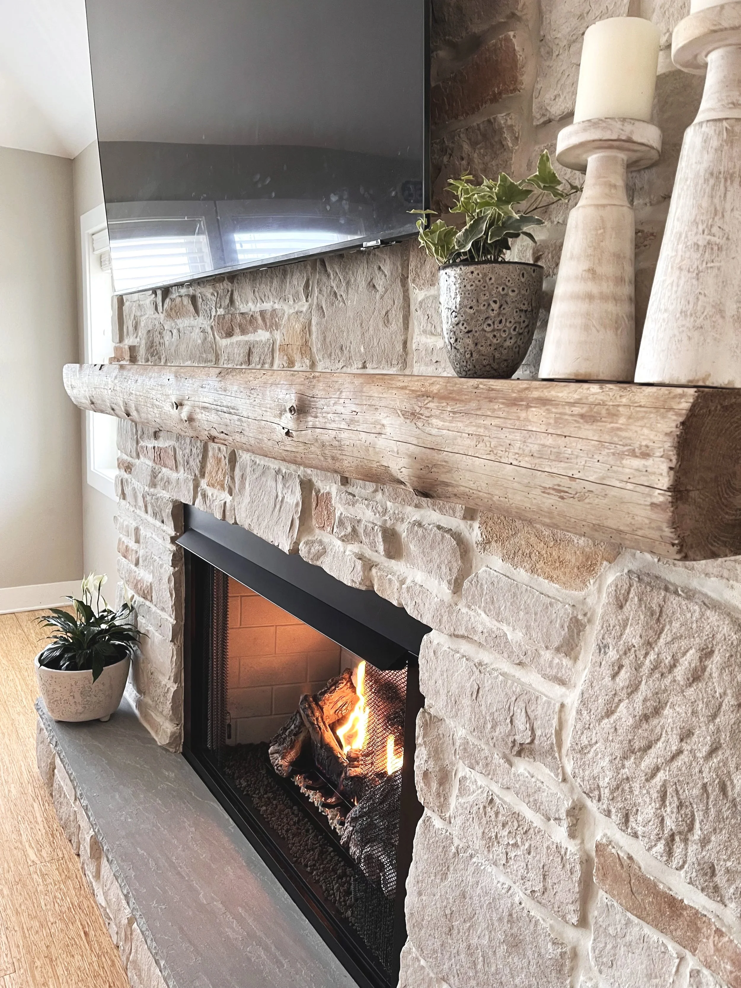 Stone fireplace renovation in Nags Head with rustic beam mantle and raised hearth 