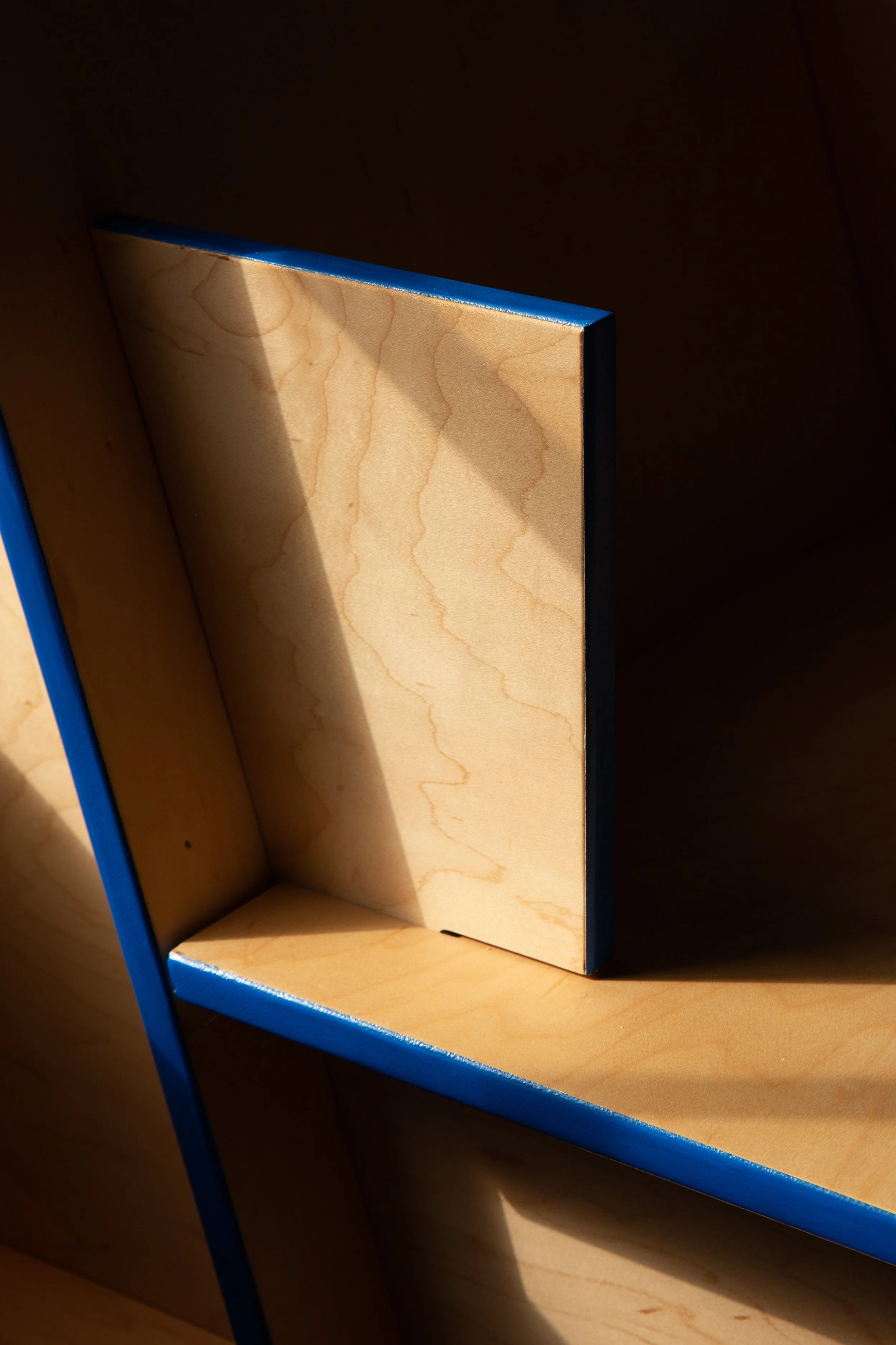A wooden box with a blue edge, inside a wooden cabinet.