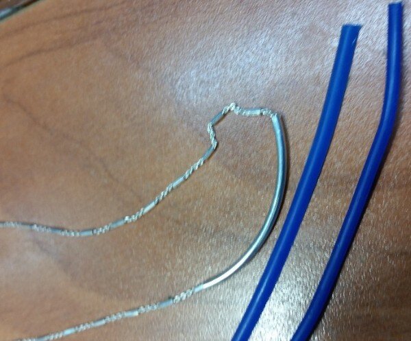 Silver necklace next to blue wax.jpeg