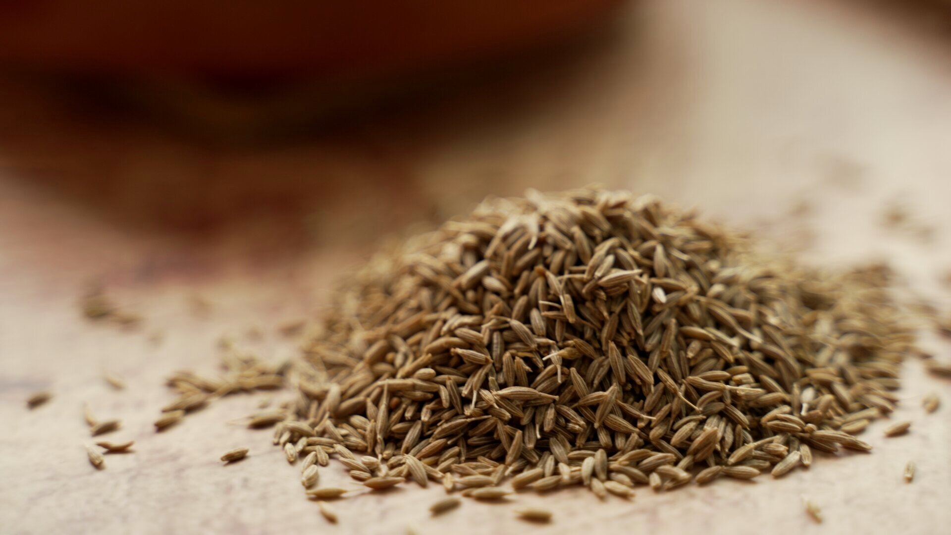 Pile of cumin seeds on a wooden surface