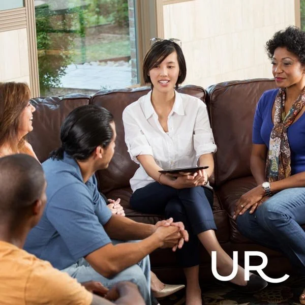 group of adults seated in a living room setting