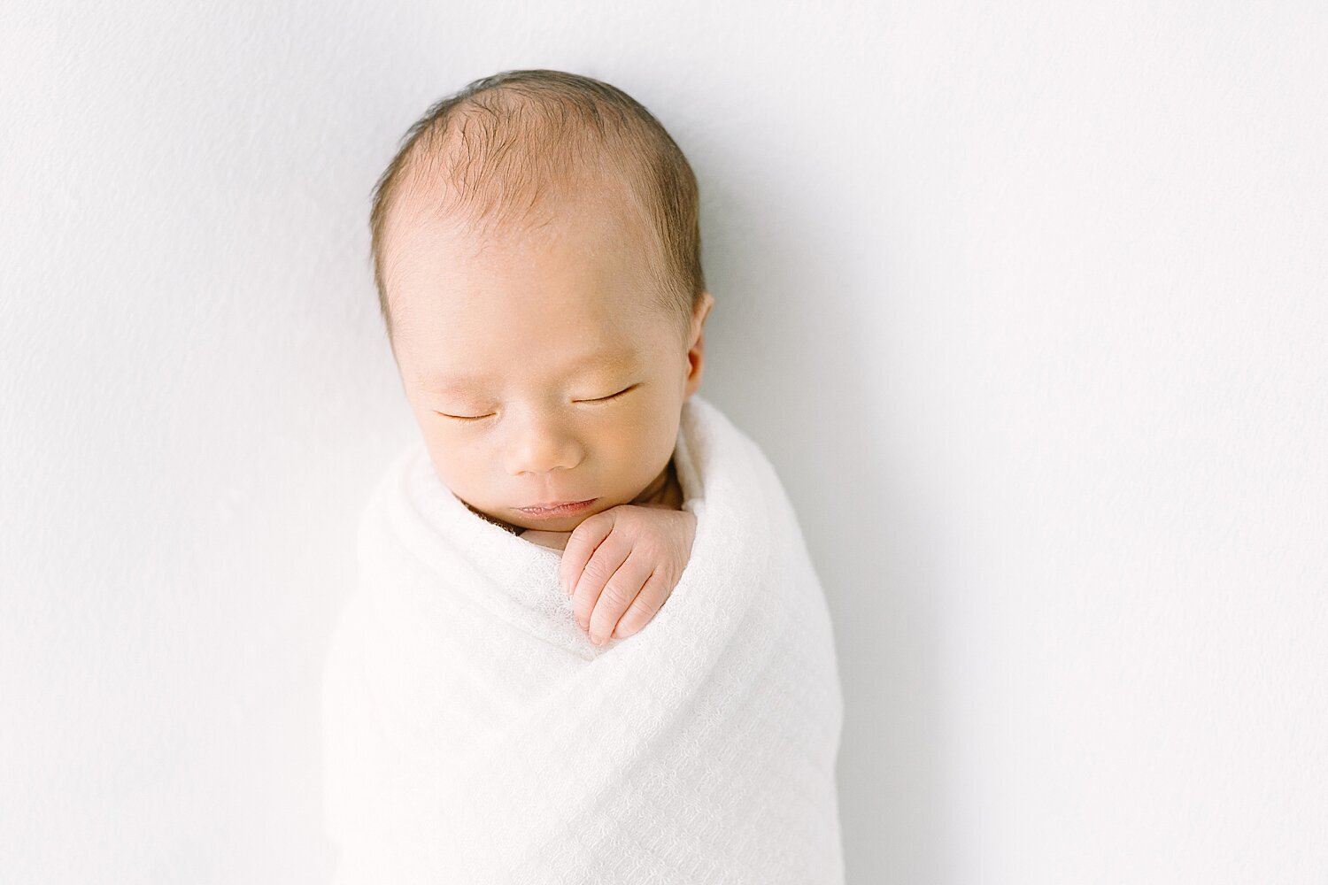 Baby boy swaddled in white | Ambre Williams Photography