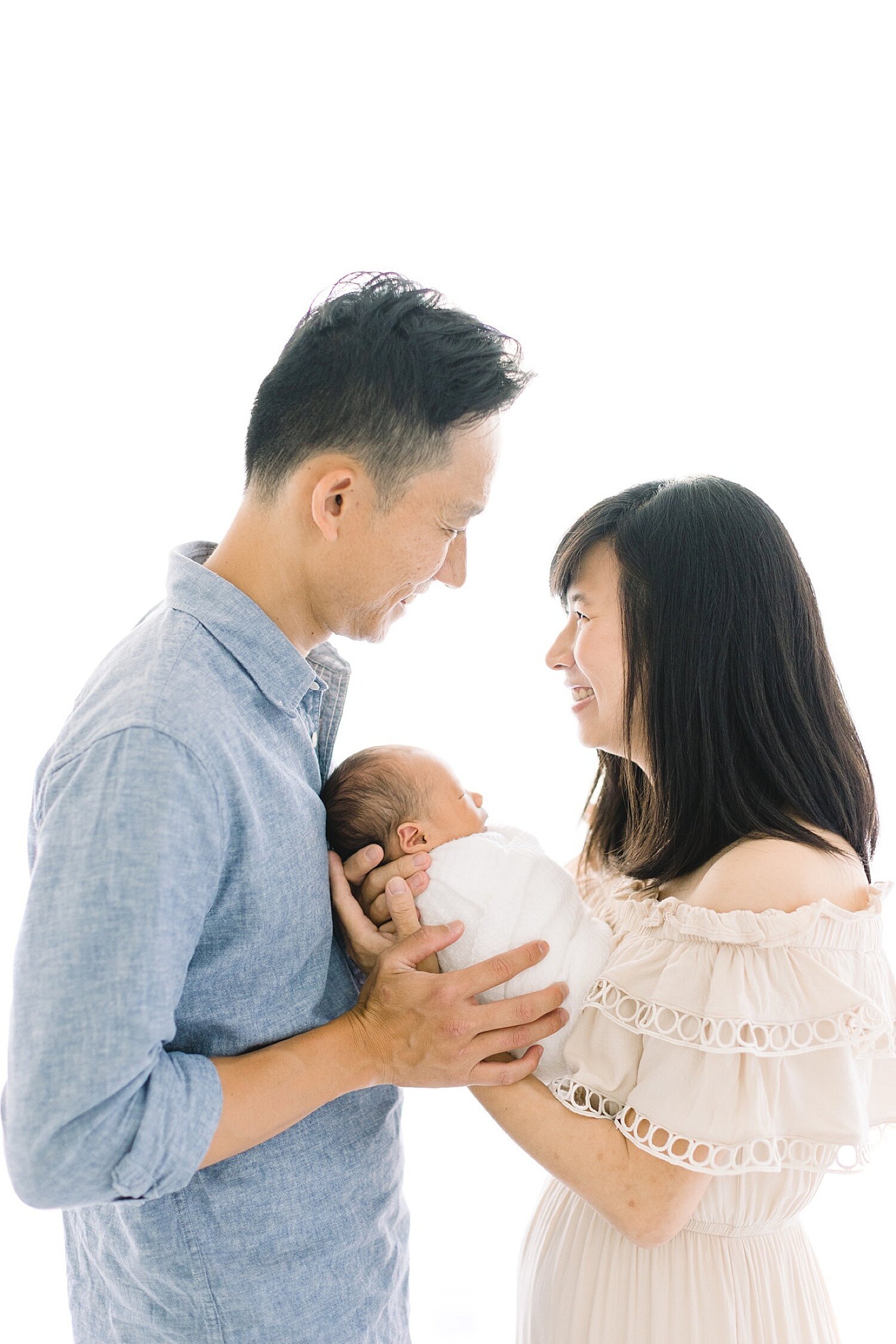 Mom and Dad with their newborn son in Newport Beach photography studio. Photo by Ambre Williams Photography.