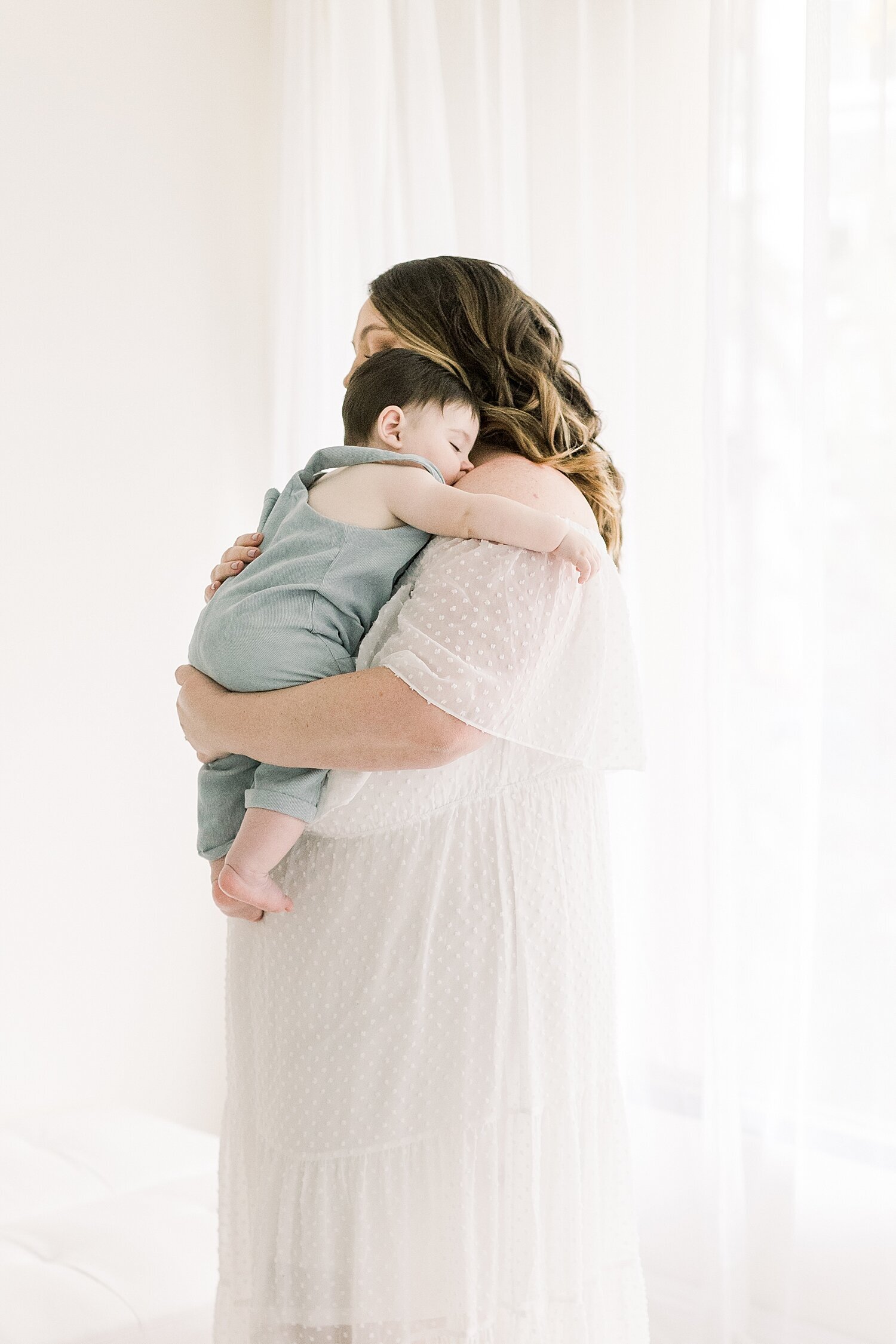 Mom snuggling her baby boy during six month milestone photoshoot with Ambre Williams Photography.