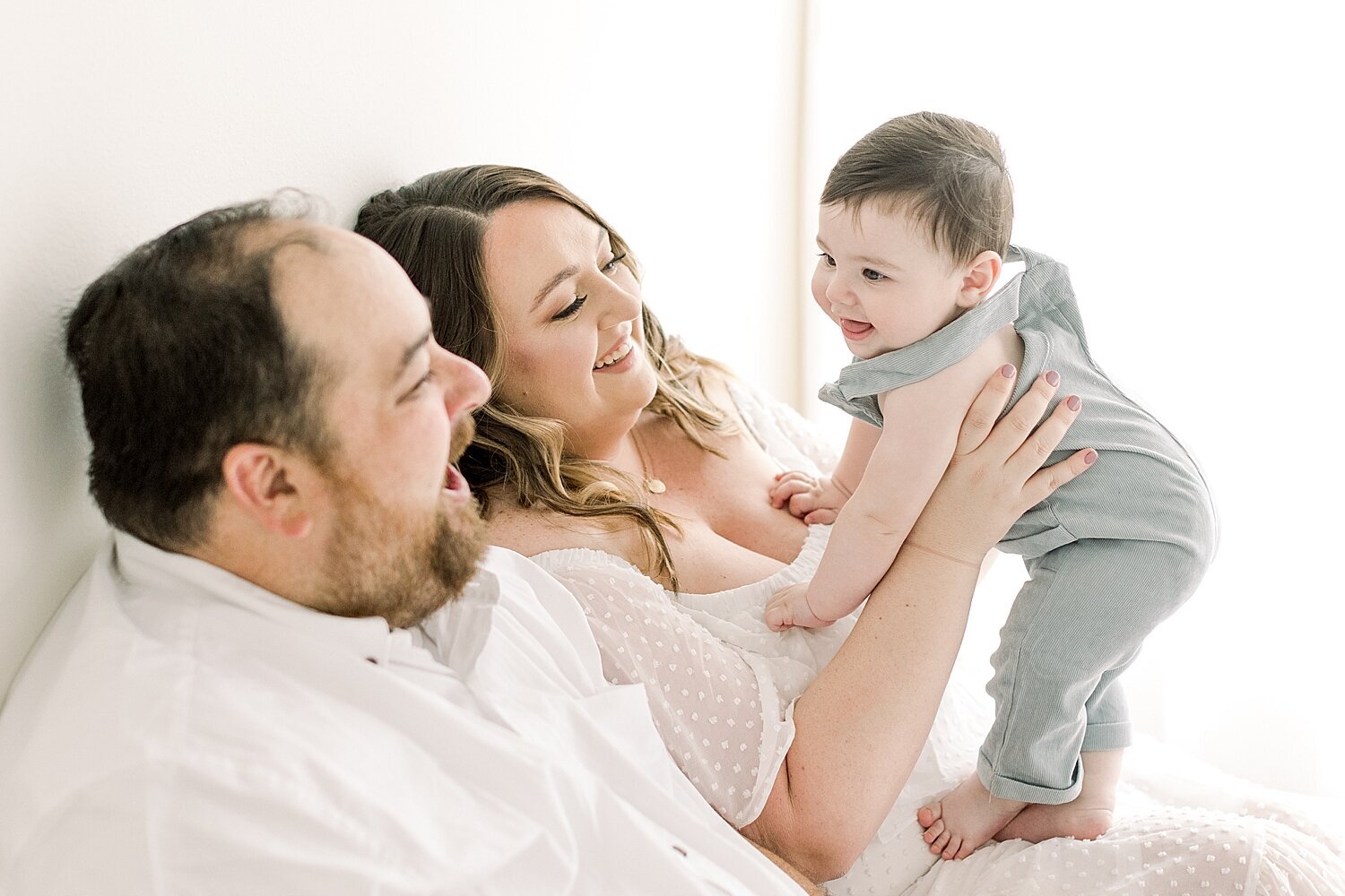 Mom and Dad interacting with their six month old son. Photo by Ambre Williams Photography.