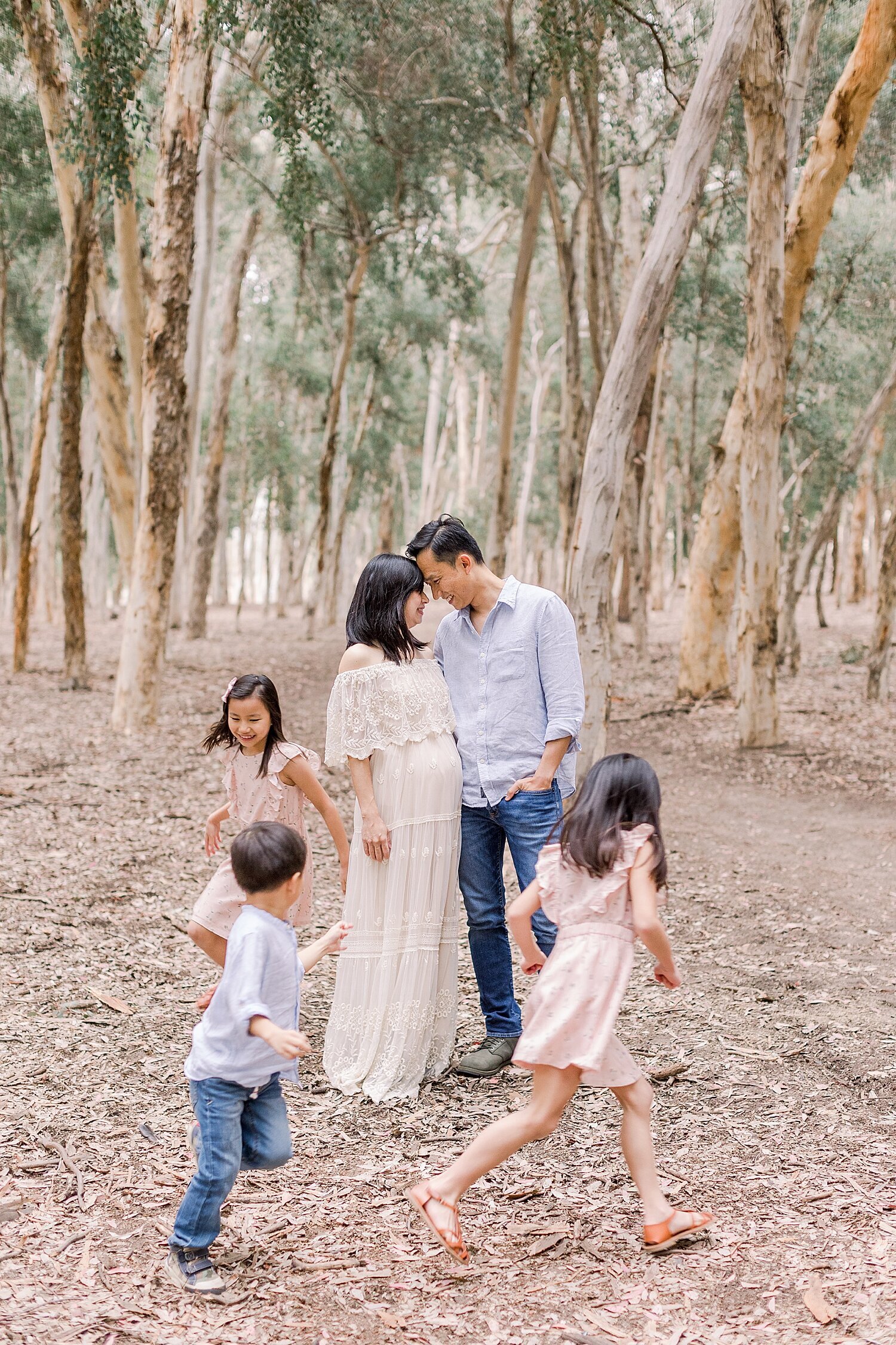 Kids running around their parents during maternity photoshoot. Photo by Ambre Williams Photography.