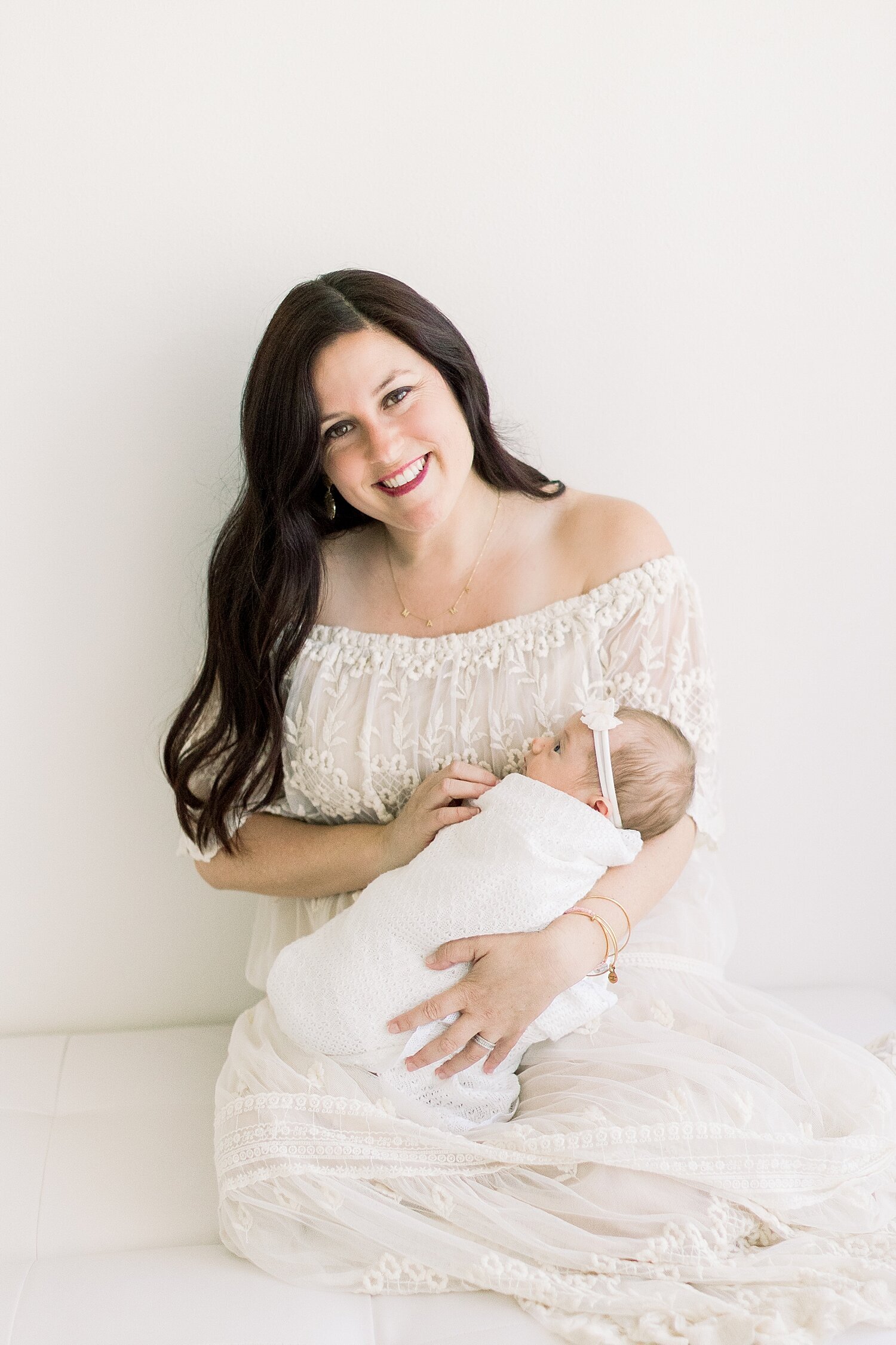 Mom holding her baby girl in studio in Newport Beach for newborn photoshoot with Ambre Williams Photography.
