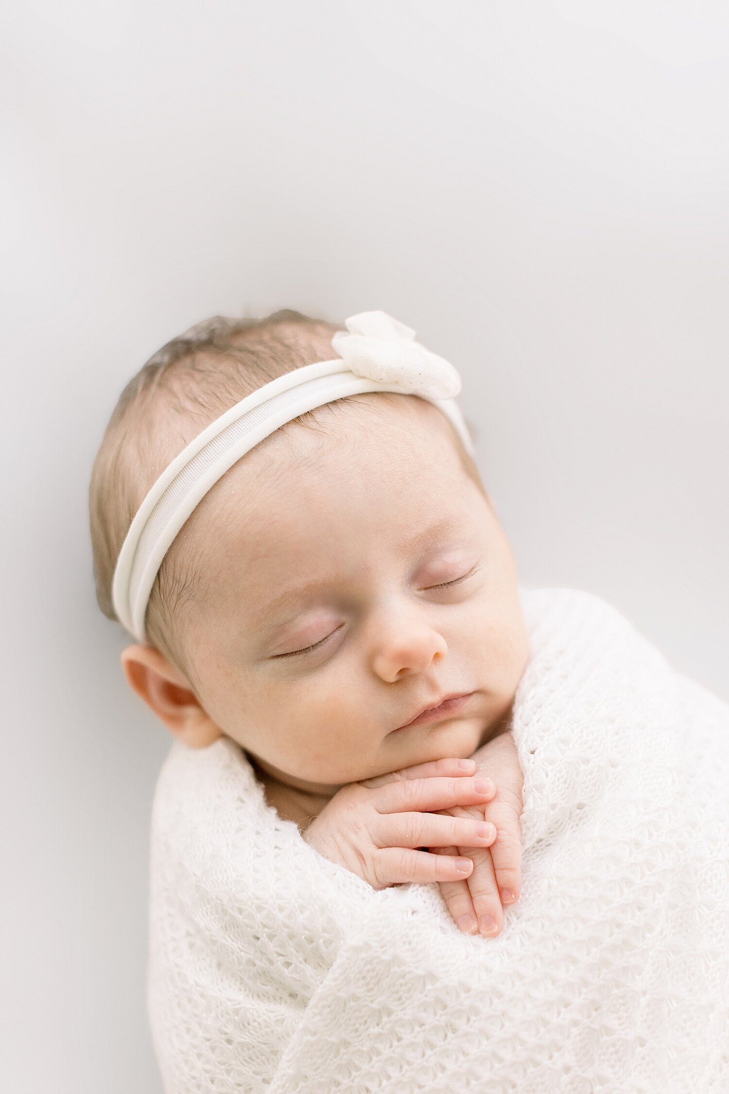 Baby girl swaddled with a sweet headband on. Photo by Ambre Williams Photography in Newport Beach, CA.