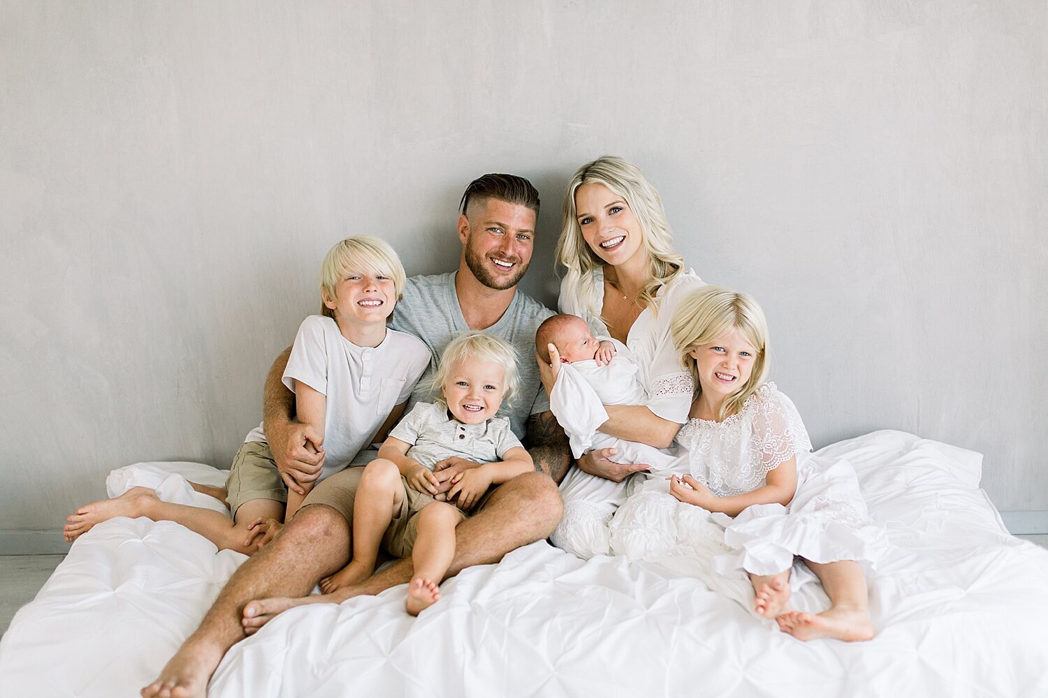 Family photo of Mom, Dad and 4 kids during newborn session in Newport Beach with Ambre Williams Photography.