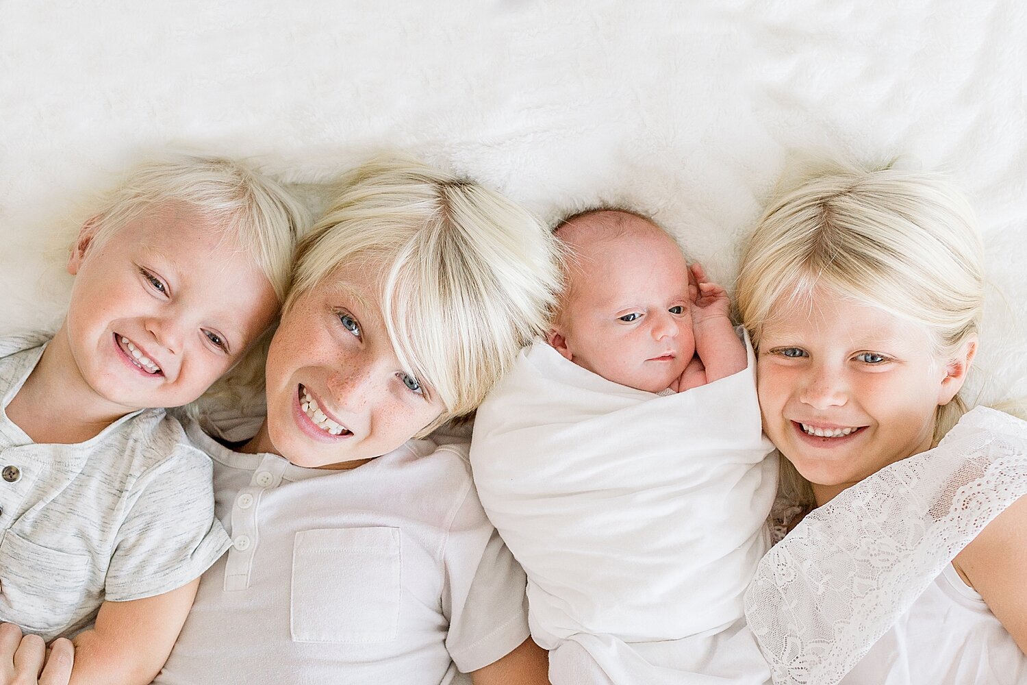 Sibling photo of 3 older siblings and newborn baby boy. Photos by Ambre Williams Photography.