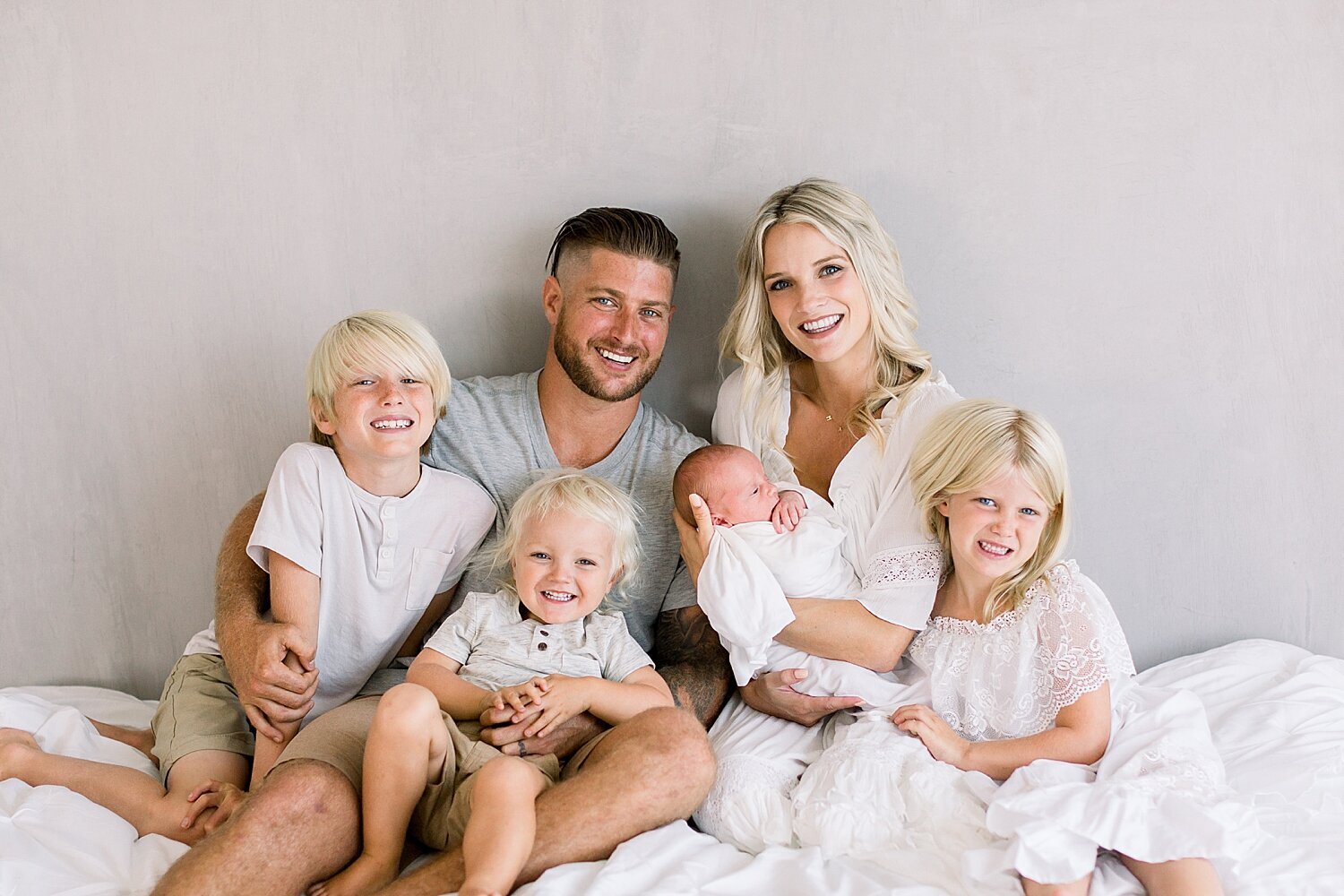 Family photo of Mom, Dad and 4 kids during newborn session in Newport Beach with Ambre Williams Photography.
