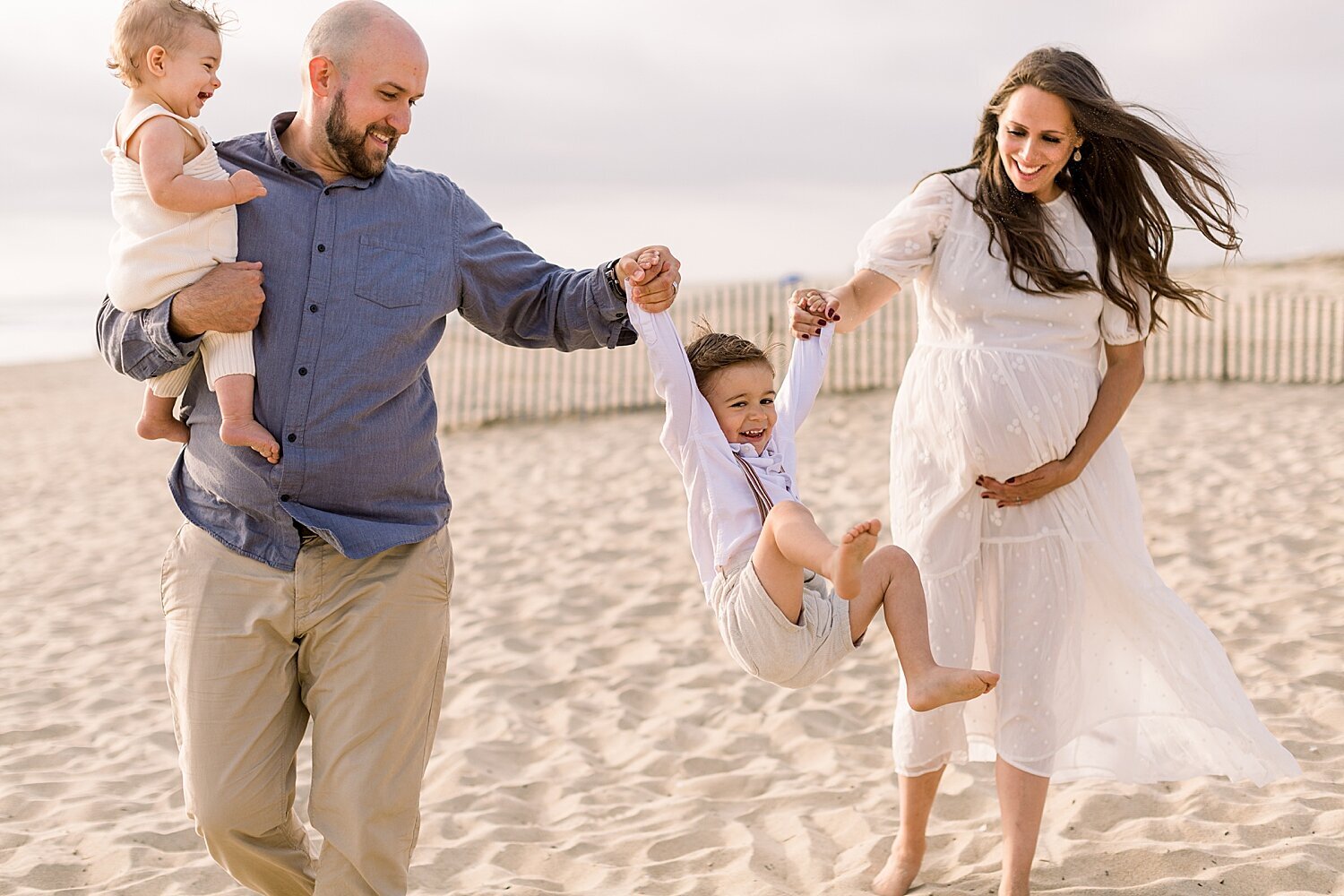 Family having fun on the beach during maternity session with Huntington Beach Photographer, Ambre Williams Photography.