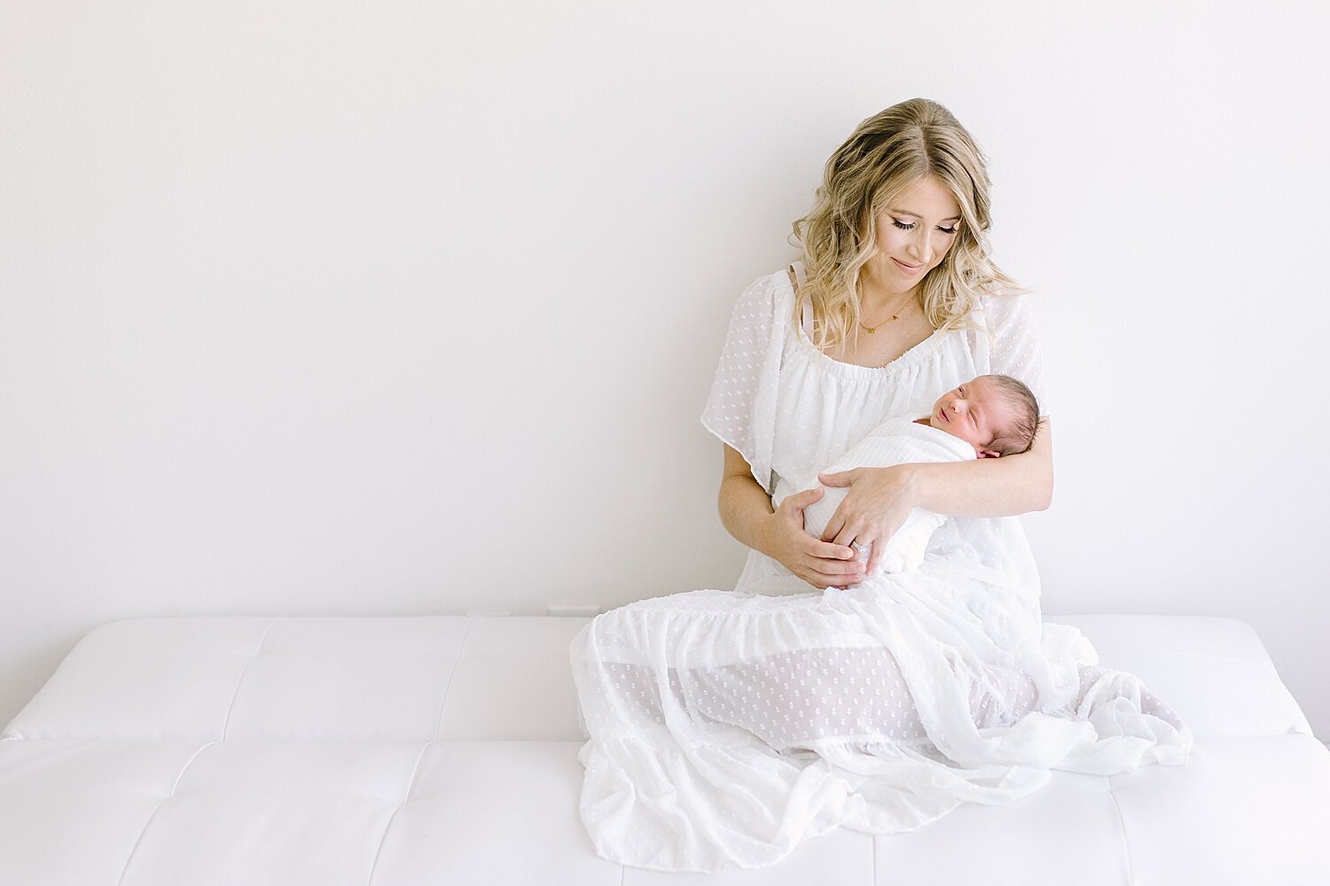 Mom wearing white dress holding her baby boy for his newborn photos | Ambre Williams Photography