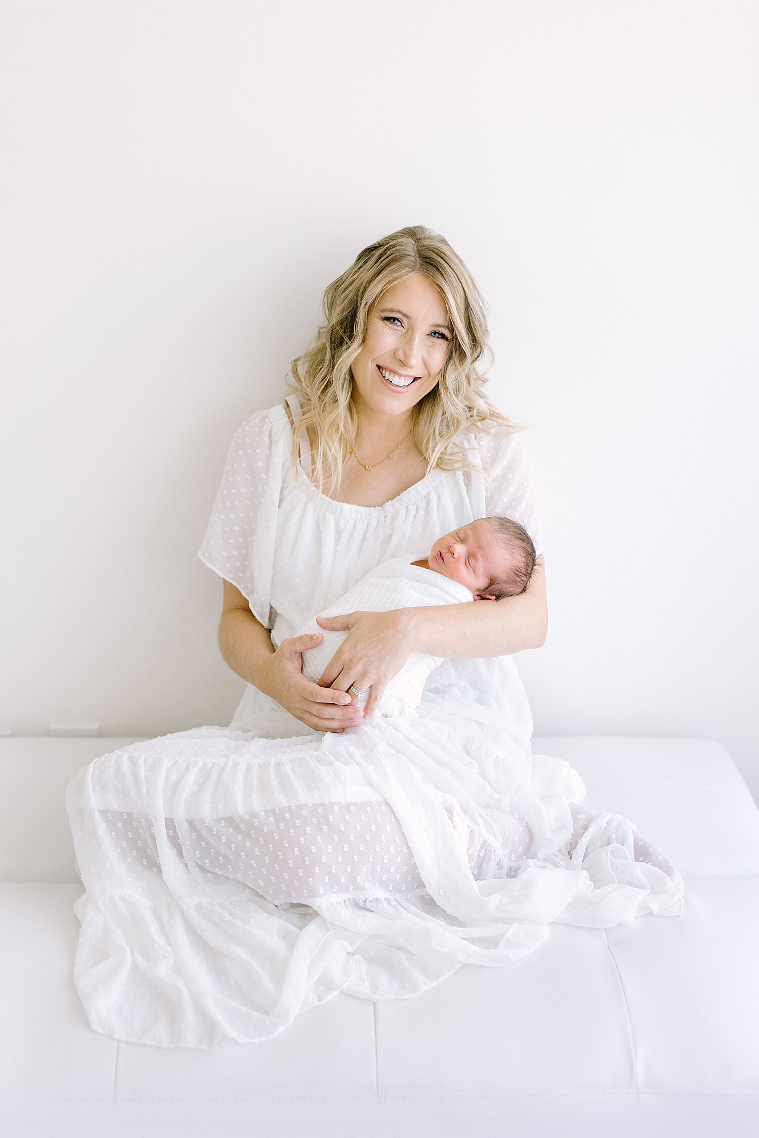 Mom wearing white dress holding her baby boy for his newborn photos | Ambre Williams Photography