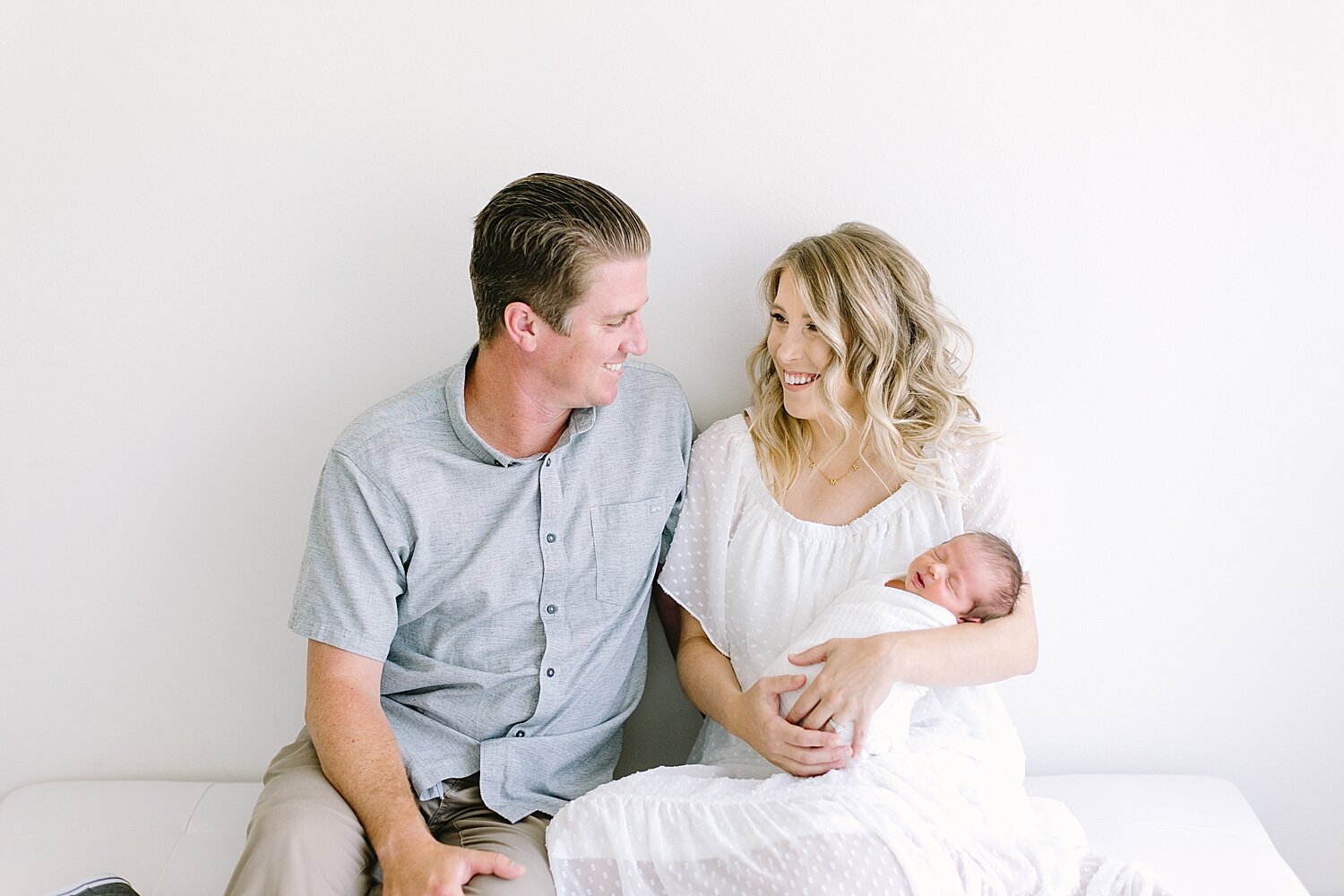 Mom and Dad holding their rainbow baby boy for newborn photos with Ambre Williams Photography.