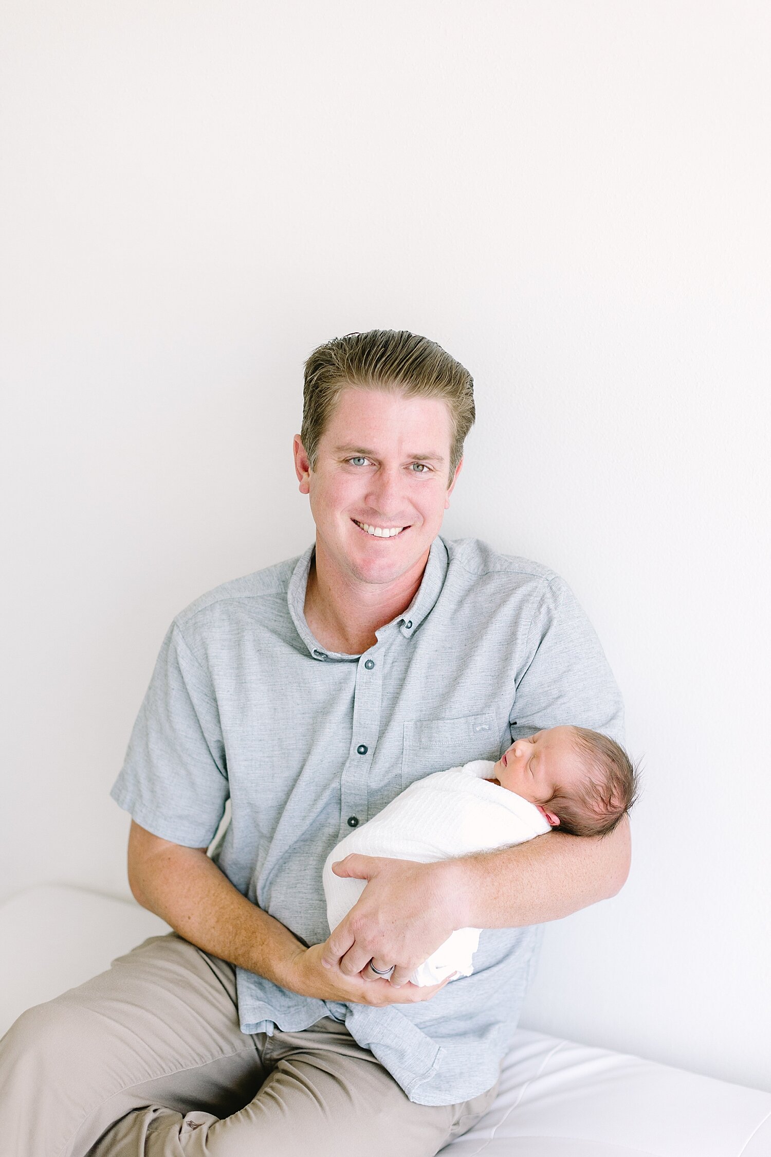 Dad holding his newborn son for photos with Ambre Williams Photography in Newport Beach, CA.