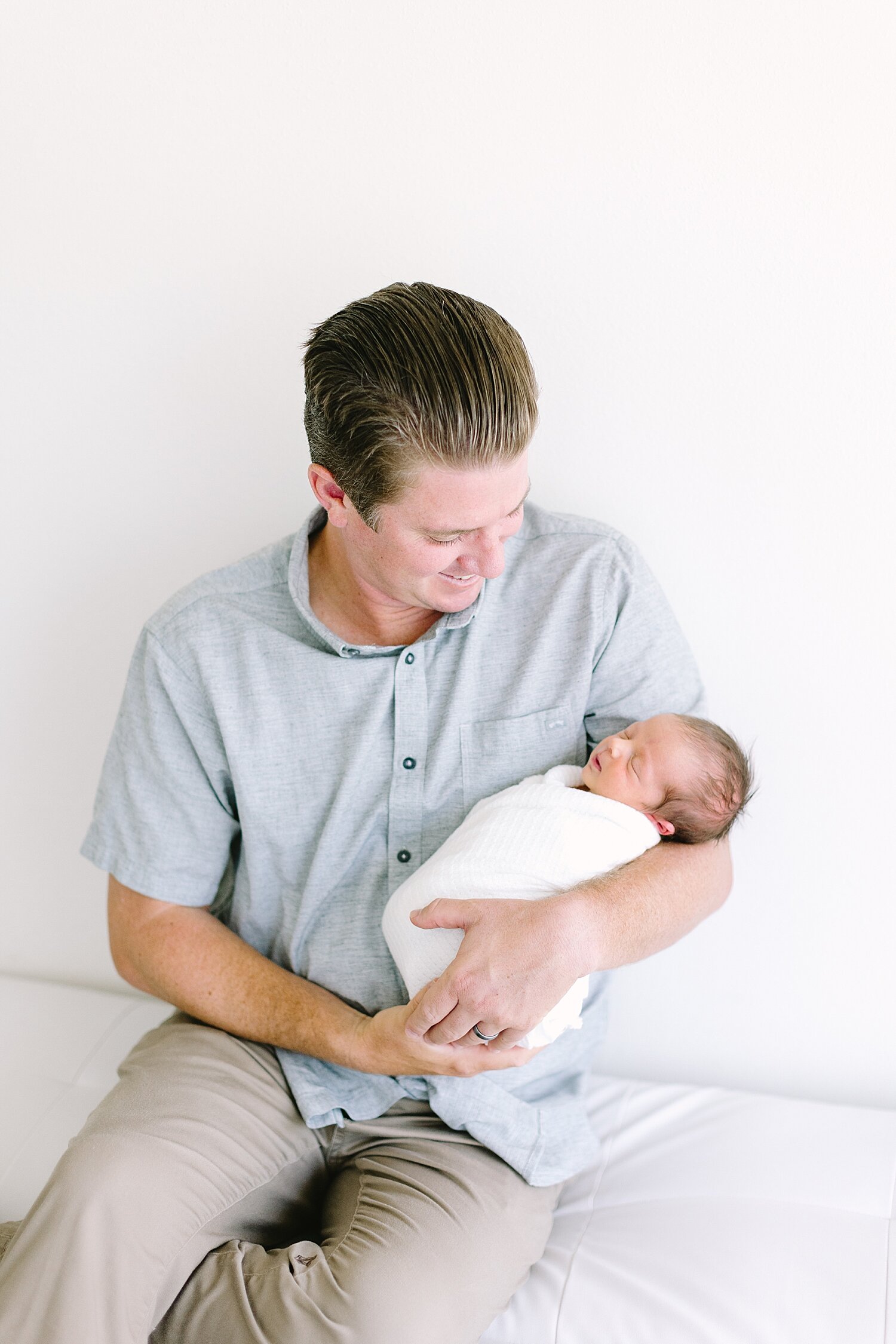 Dad holding his newborn son for photos with Ambre Williams Photography in Newport Beach, CA.