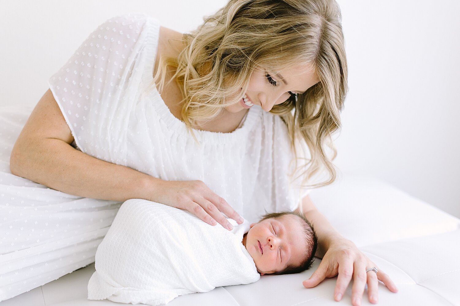 Photo of Mom laying with her son during newborn session with Ambre Williams Photography.