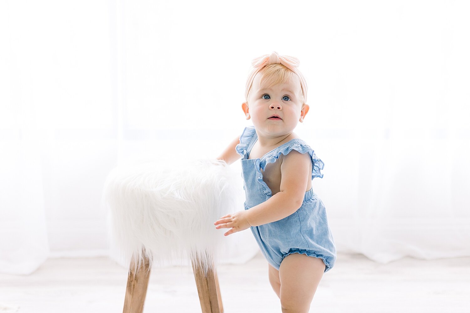 One year old standing by a stool for first birthday photoshoot with Ambre Williams Photography.
