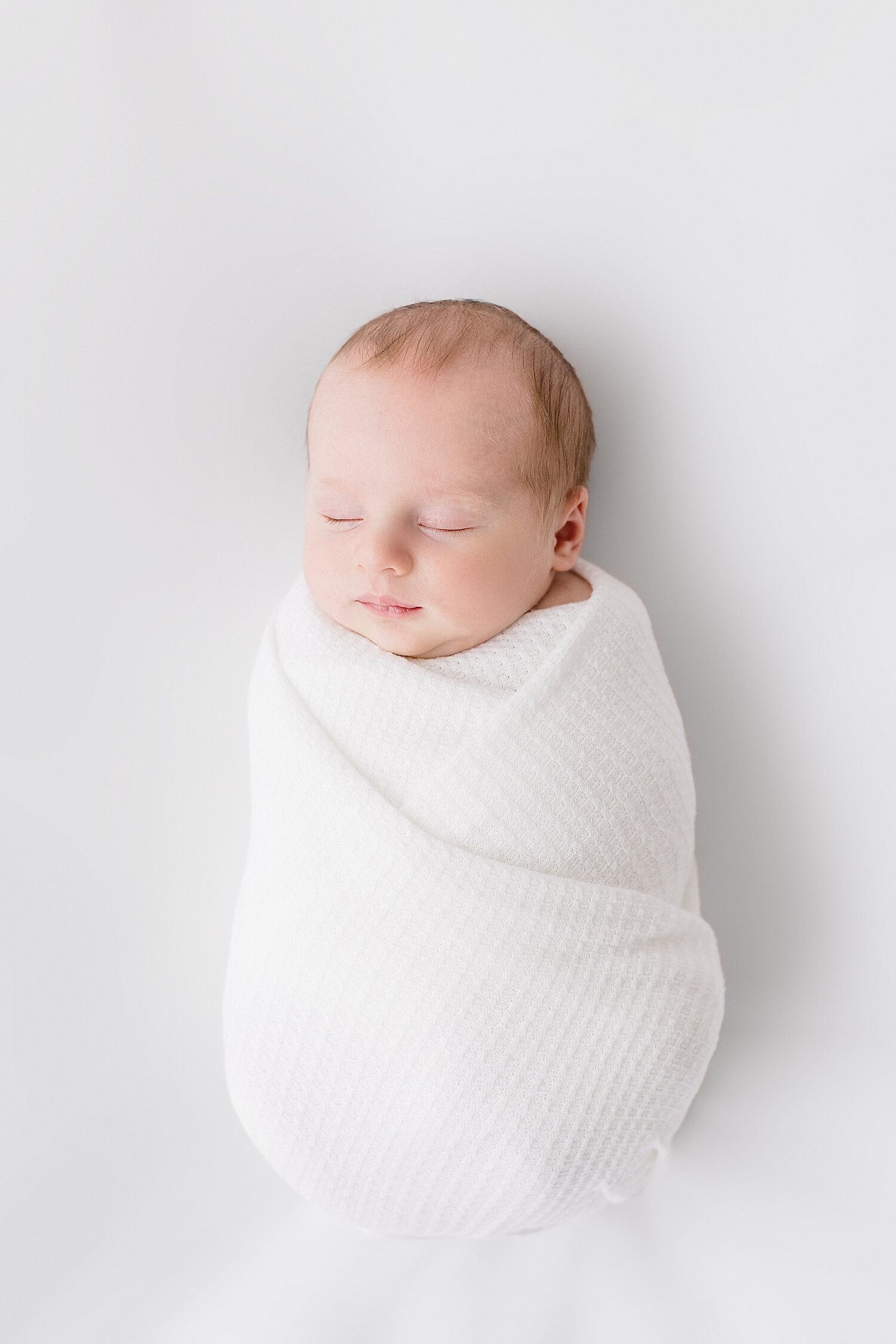 Baby boy swaddled in white | Ambre Williams Photography