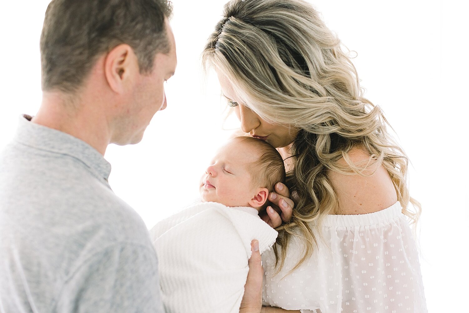 Mom and Dad holding their son during newborn session with Ambre Williams Photography. 