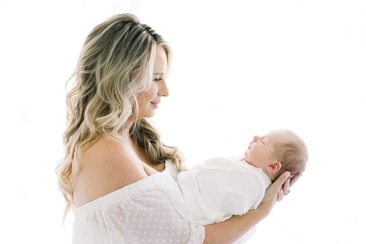 Mom holding her newborn son during photoshoot with Ambre Williams Photography.