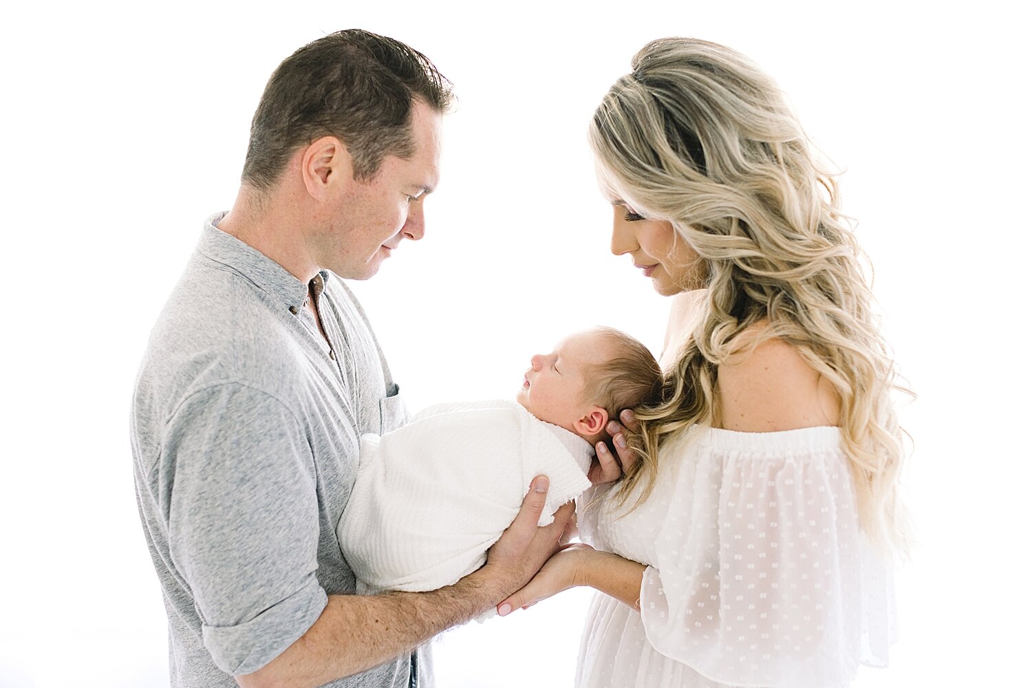 Mom and Dad holding their son during newborn session with Ambre Williams Photography. 