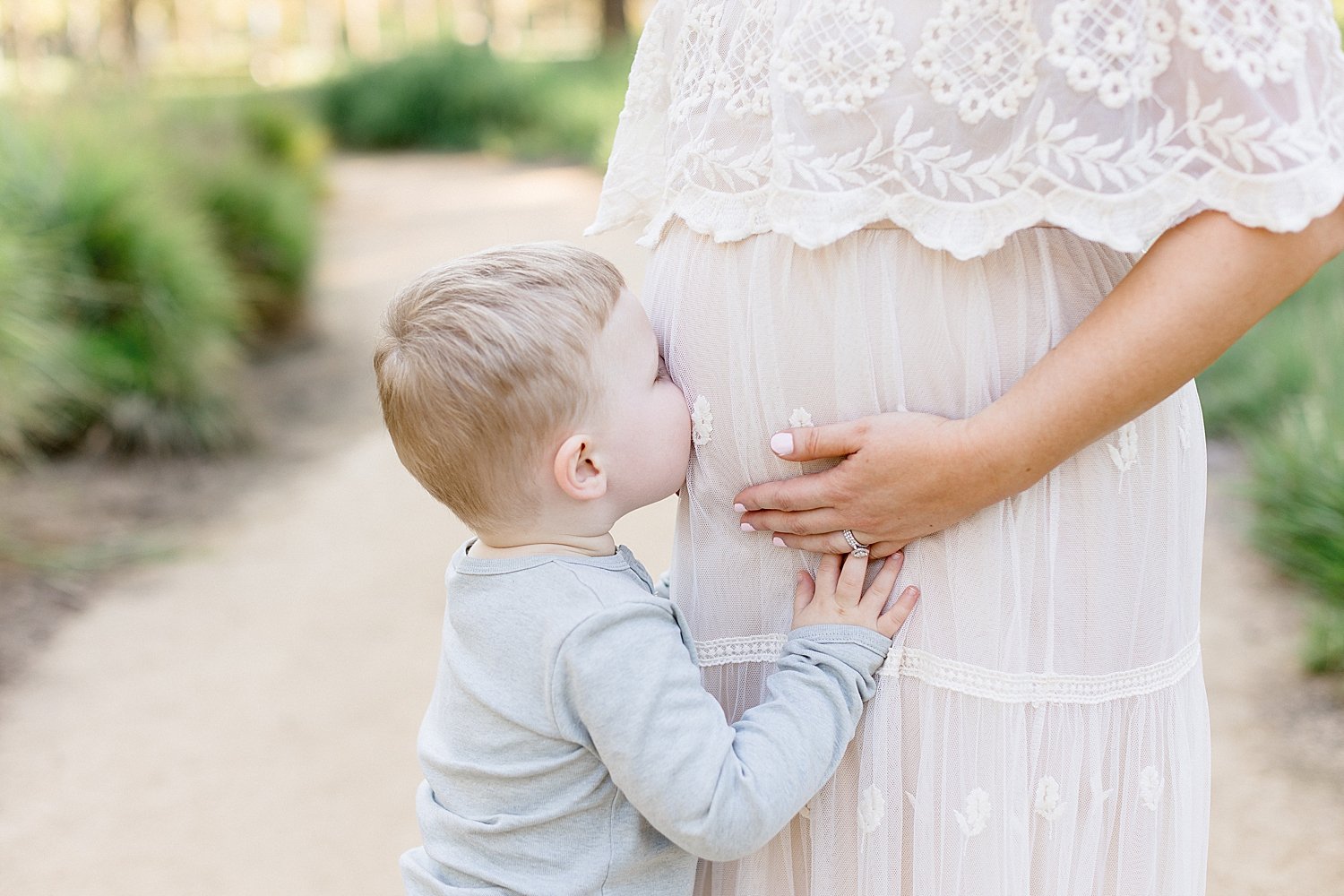 Big brother kissing Mom's belly. Photo by Ambre Williams Photography.