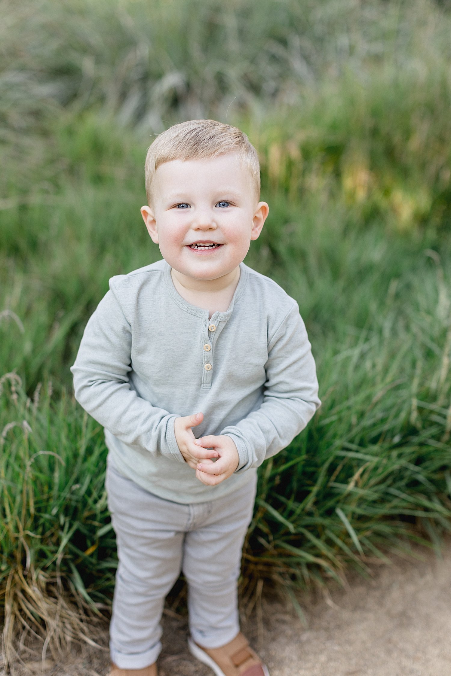 Toddler smiling for photos with Ambre Williams Photography.