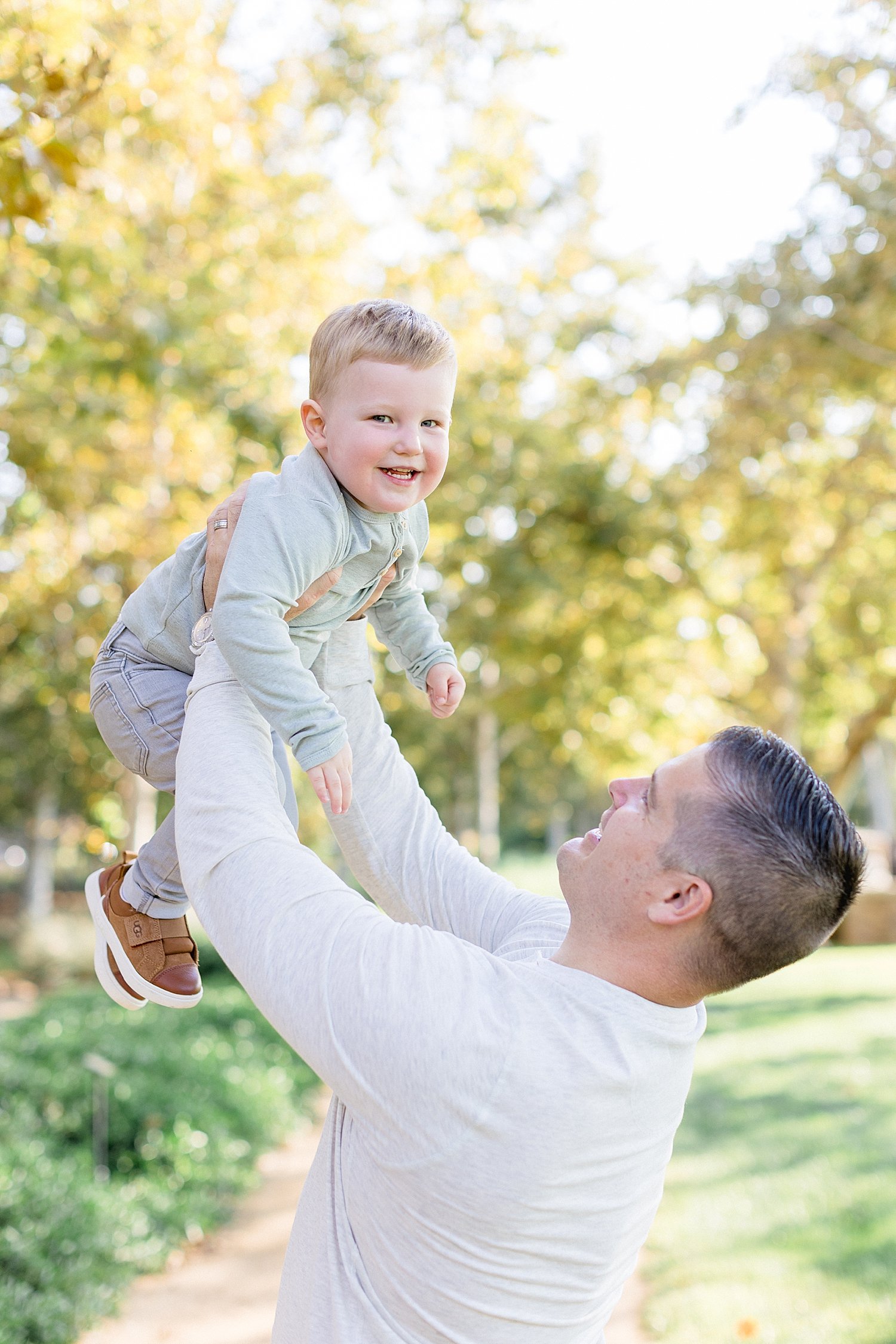Dad holding son up in the air for photos with Ambre Williams Photography.