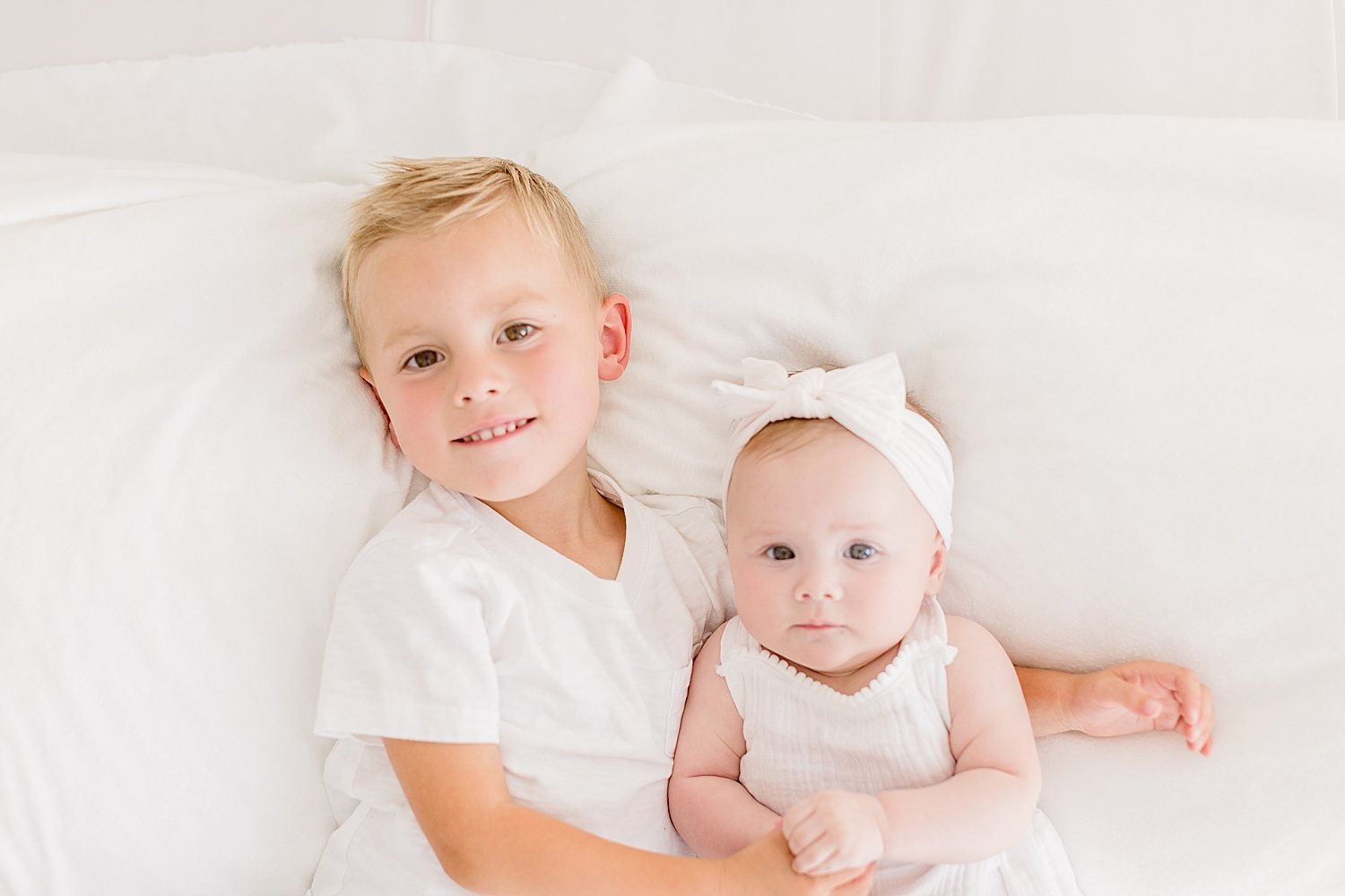 Brother and sister laying together for photos with Ambre Williams Photography.