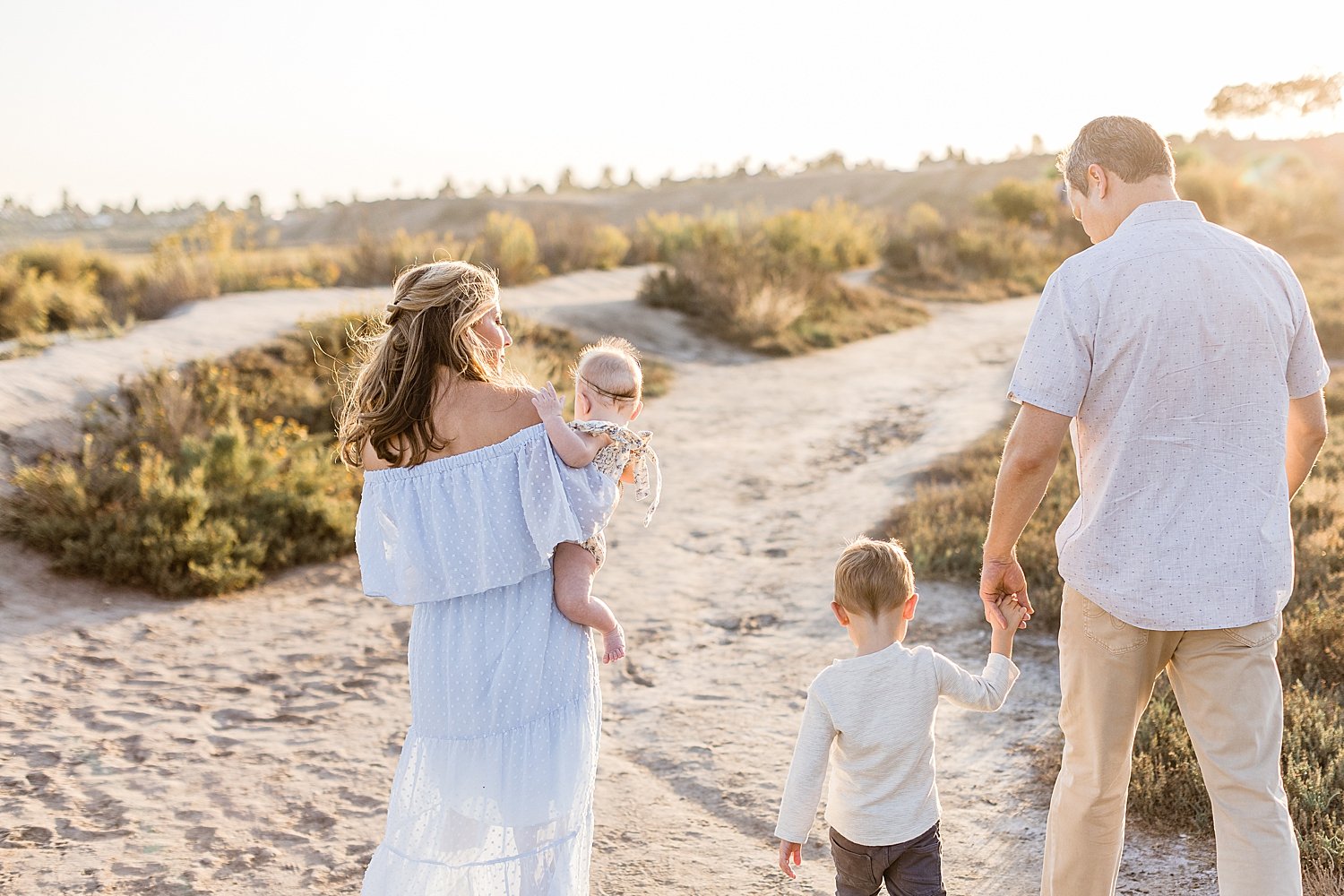 Family walking along path at sunset for family portraits with Ambre Williams Photography