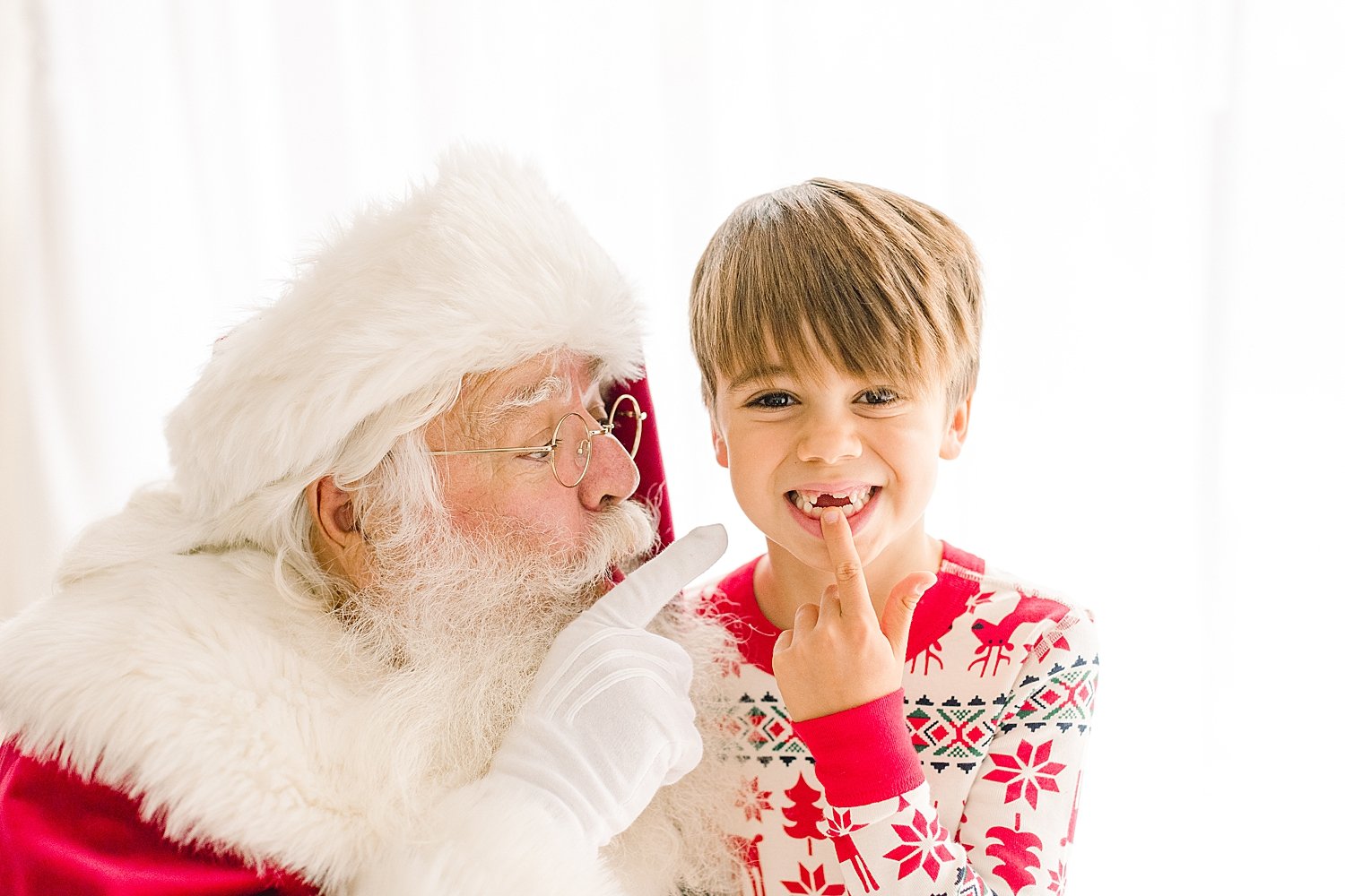 Young boy telling Santa he wants his two front teeth for Christmas | Ambre Williams Photography