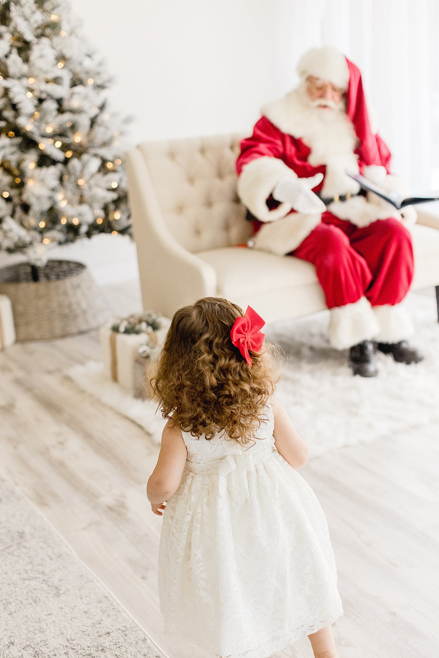 Toddler visiting Santa from a distance  | Ambre Williams Photography