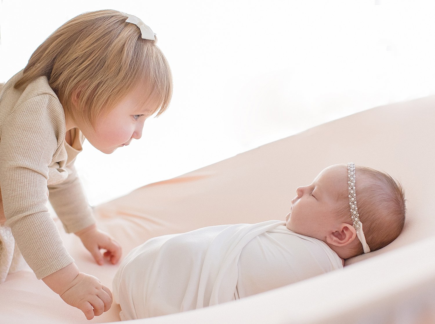 Big sister looking over baby sister | Ambre Williams Photography