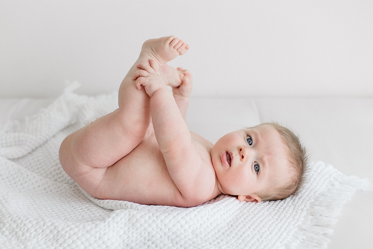 Six month old baby boy playing with toes | Ambre Williams Photography