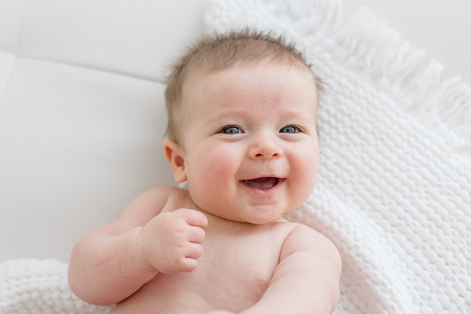 Six month old baby boy laughing for photos with Ambre Williams Photography