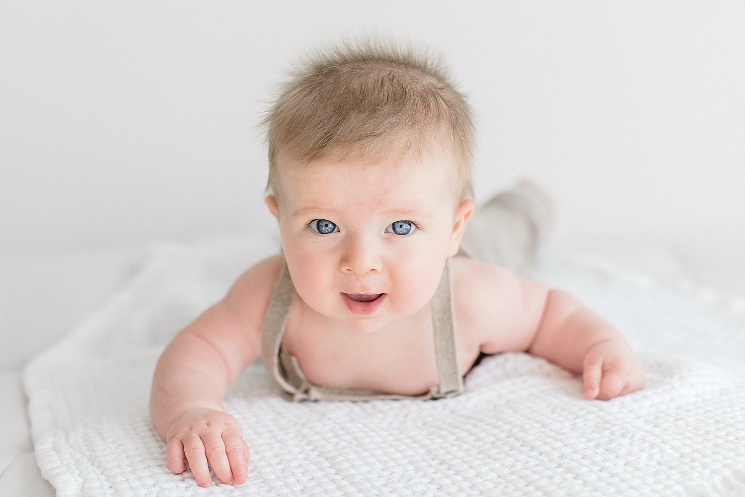 Six month old baby boy laying on his stomach lifting his head | Ambre Williams Photography