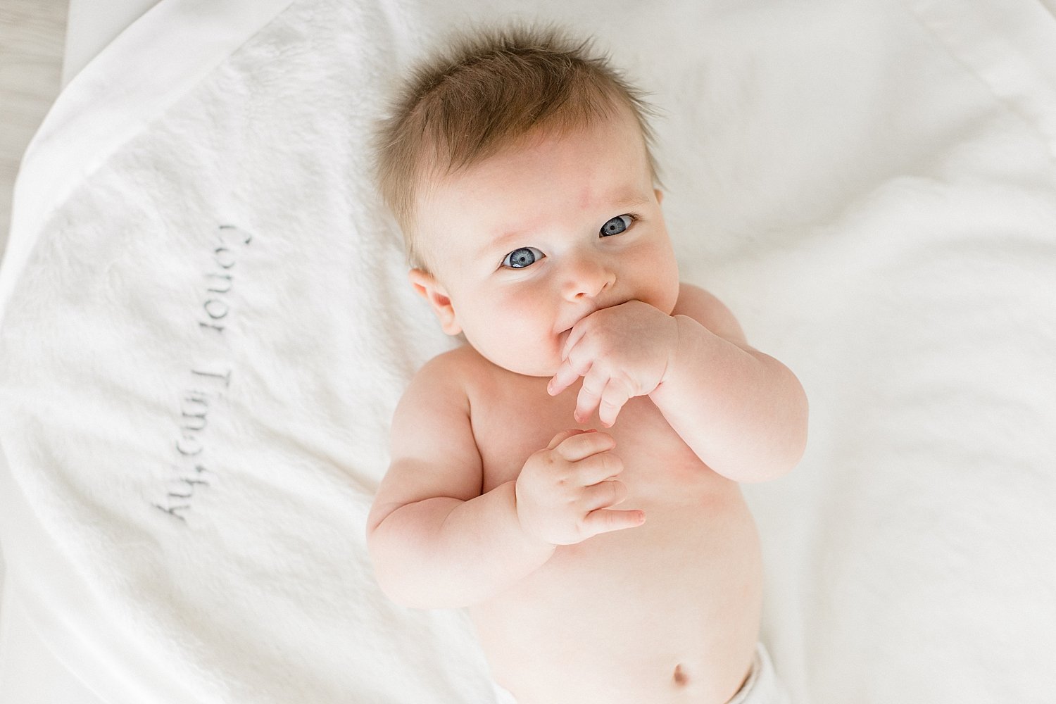 Six month old baby boy laying on blanket | Ambre Williams Photography